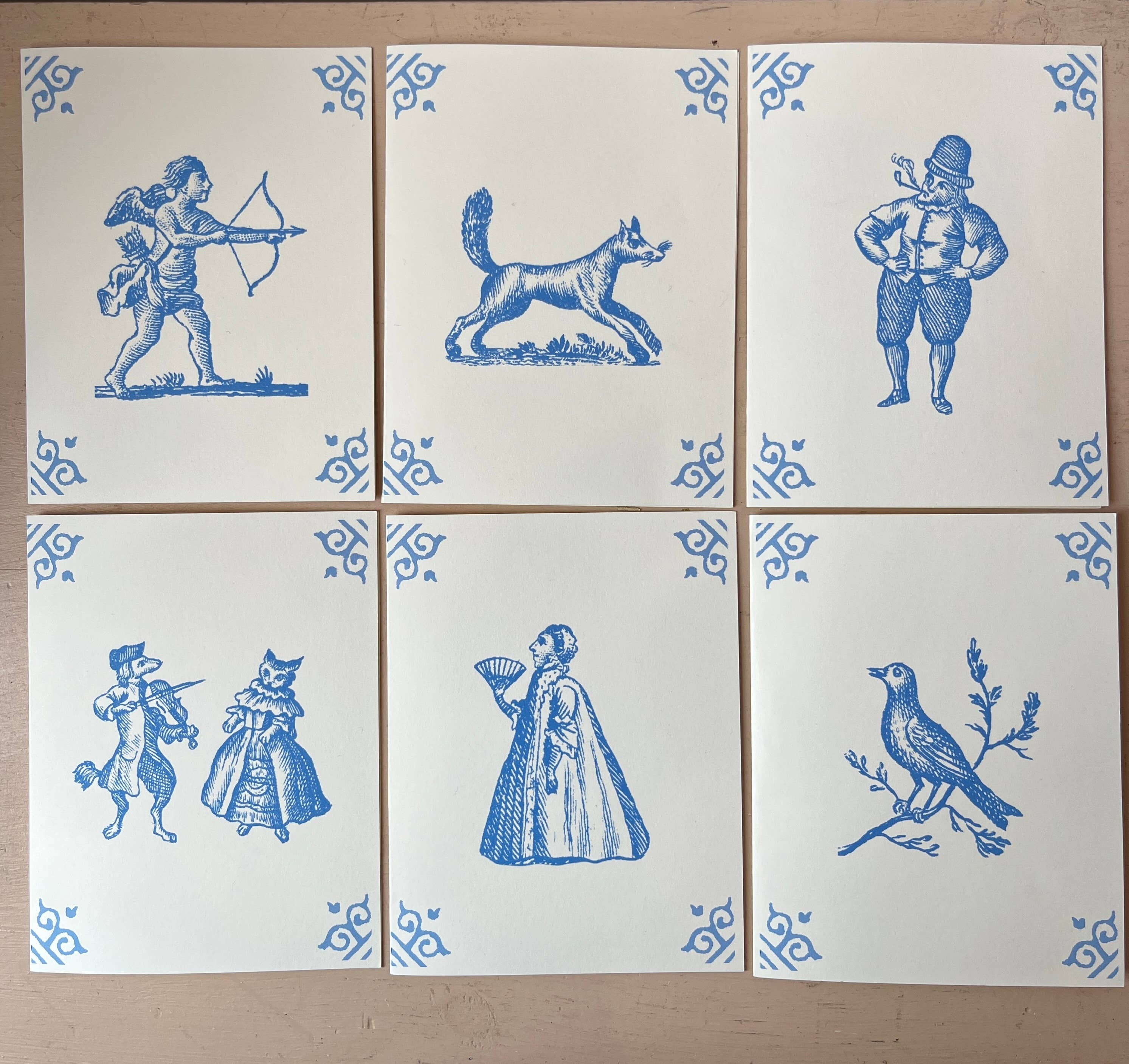 Set of Dutch-style cards with blue dog and cat scenes plus archer, musician, woman, bird