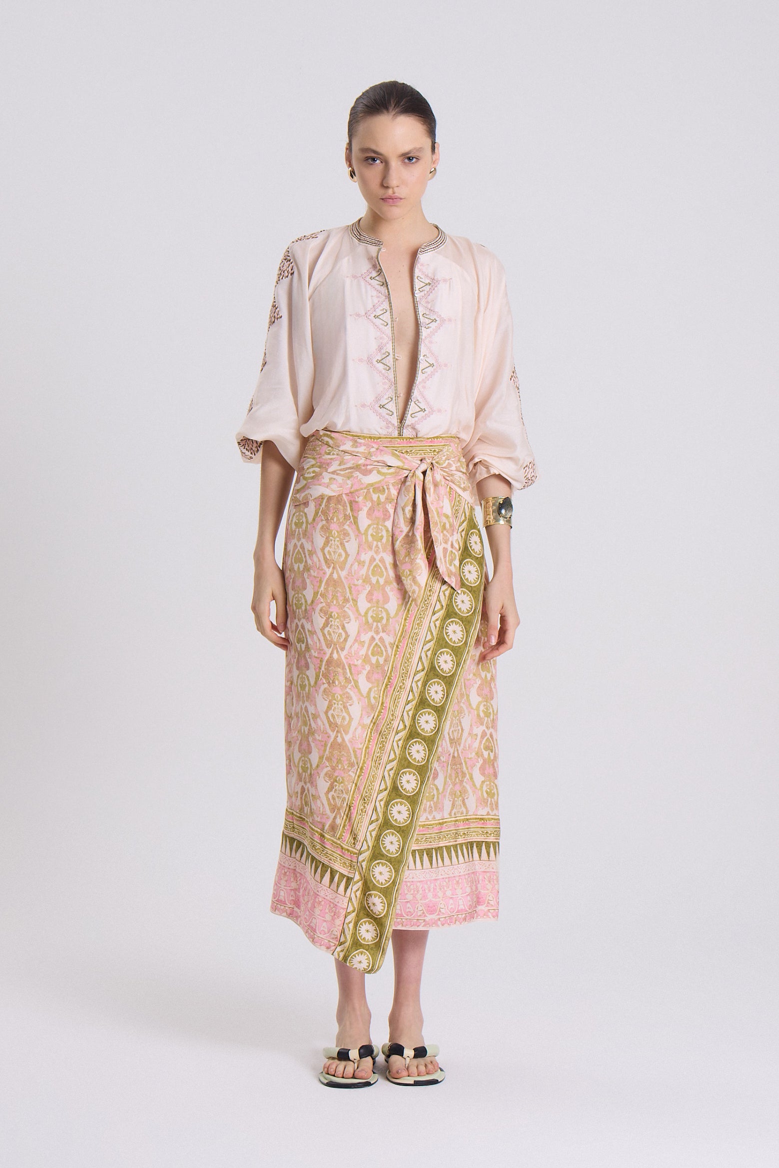 Light pink patterned midi skirt with green and gold border stripe, wrap-style tie