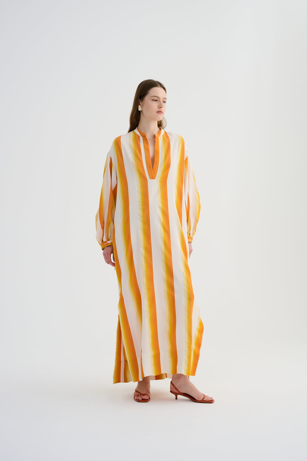 Yellow maxi caftan dress with vertical orange-and-white stripes, V-neck, draped fit.
