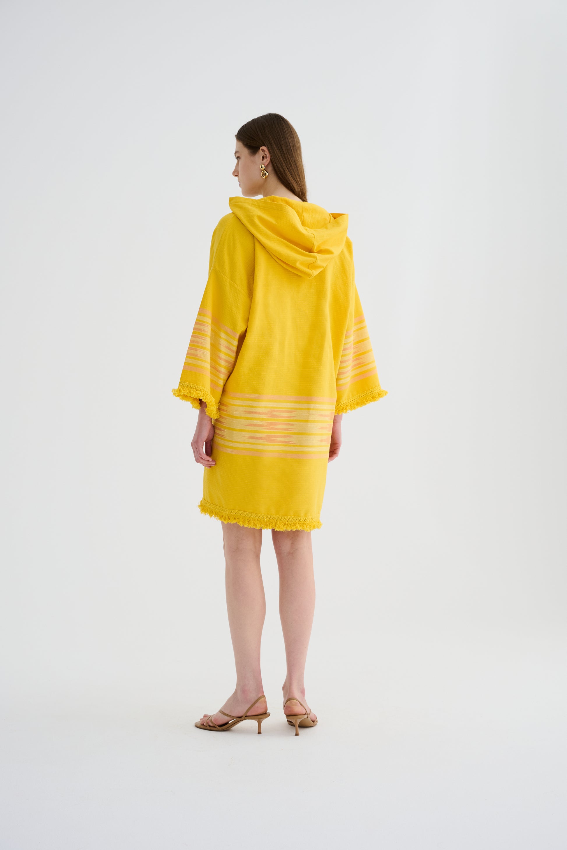 Yellow hooded mini dress with hood, striped sleeve bands, and fringed hem