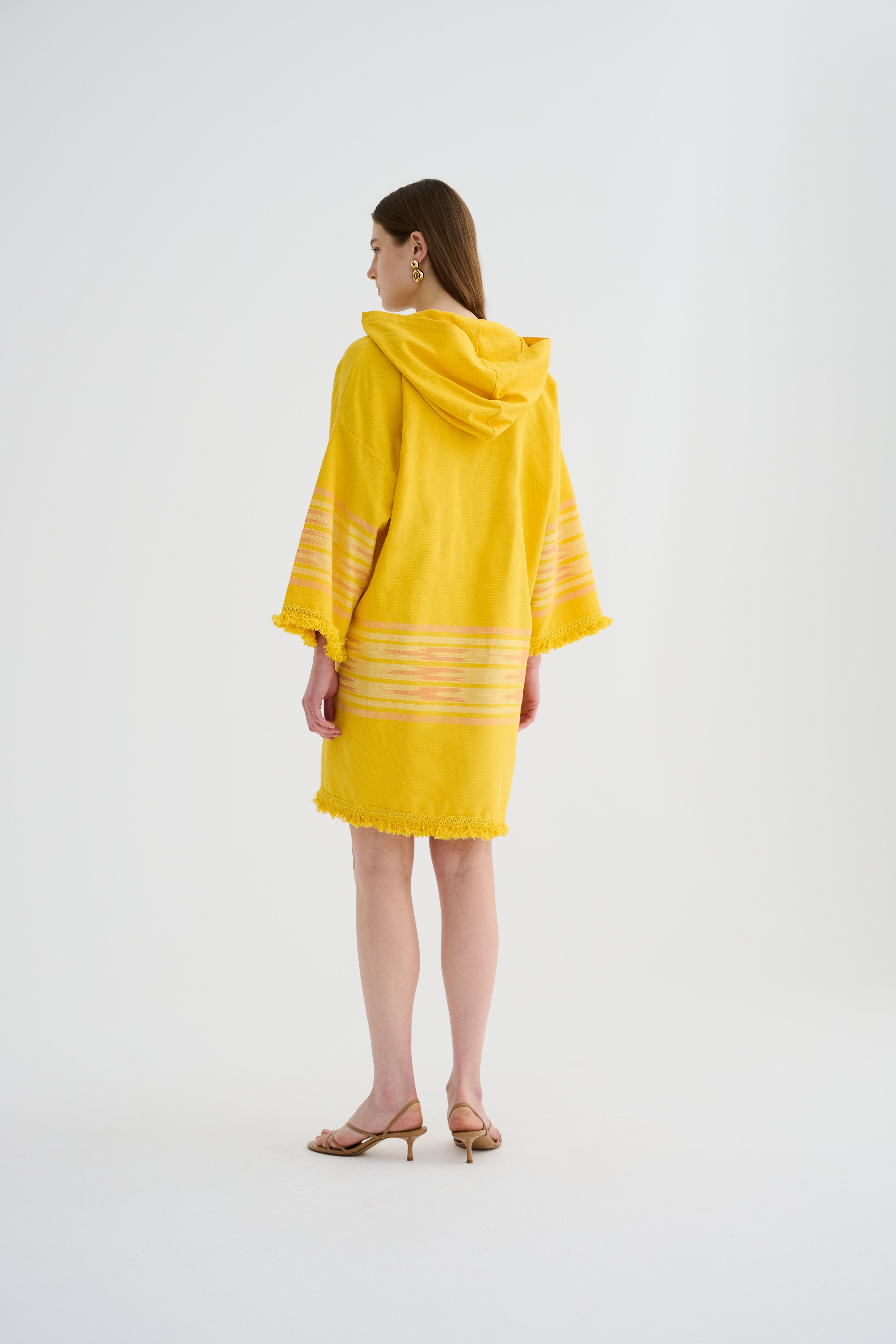 Yellow hooded mini dress with hood, striped sleeve bands, and fringed hem