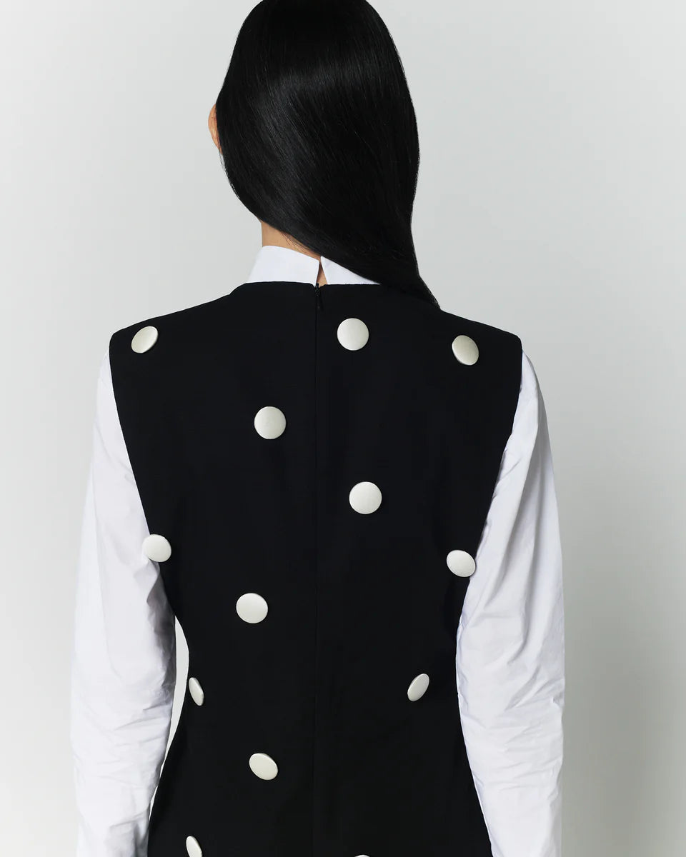 Polka dot sleeveless midi dress, black with white dots, back view.