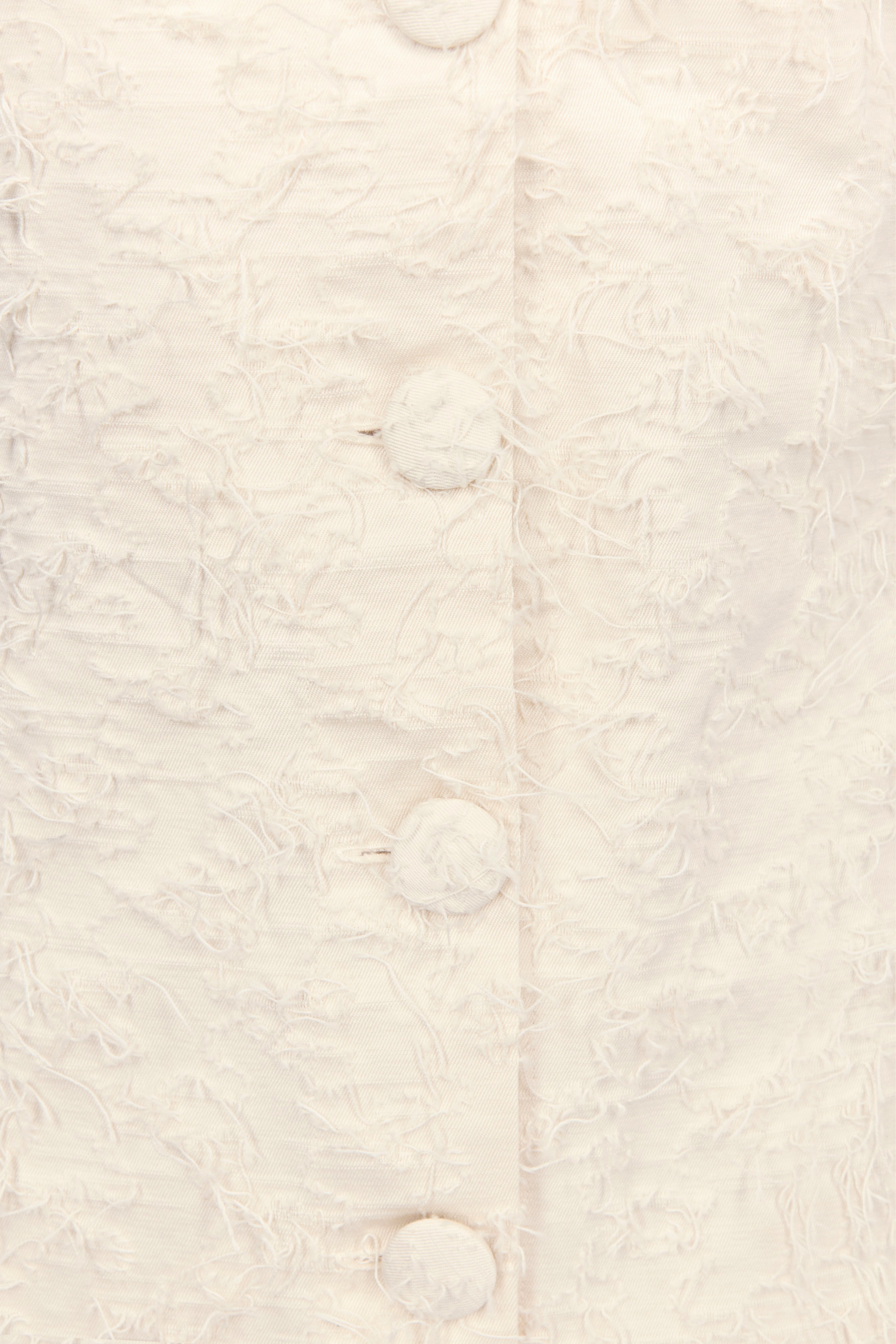 Cream textured fabric with round buttons on sleeveless dress front