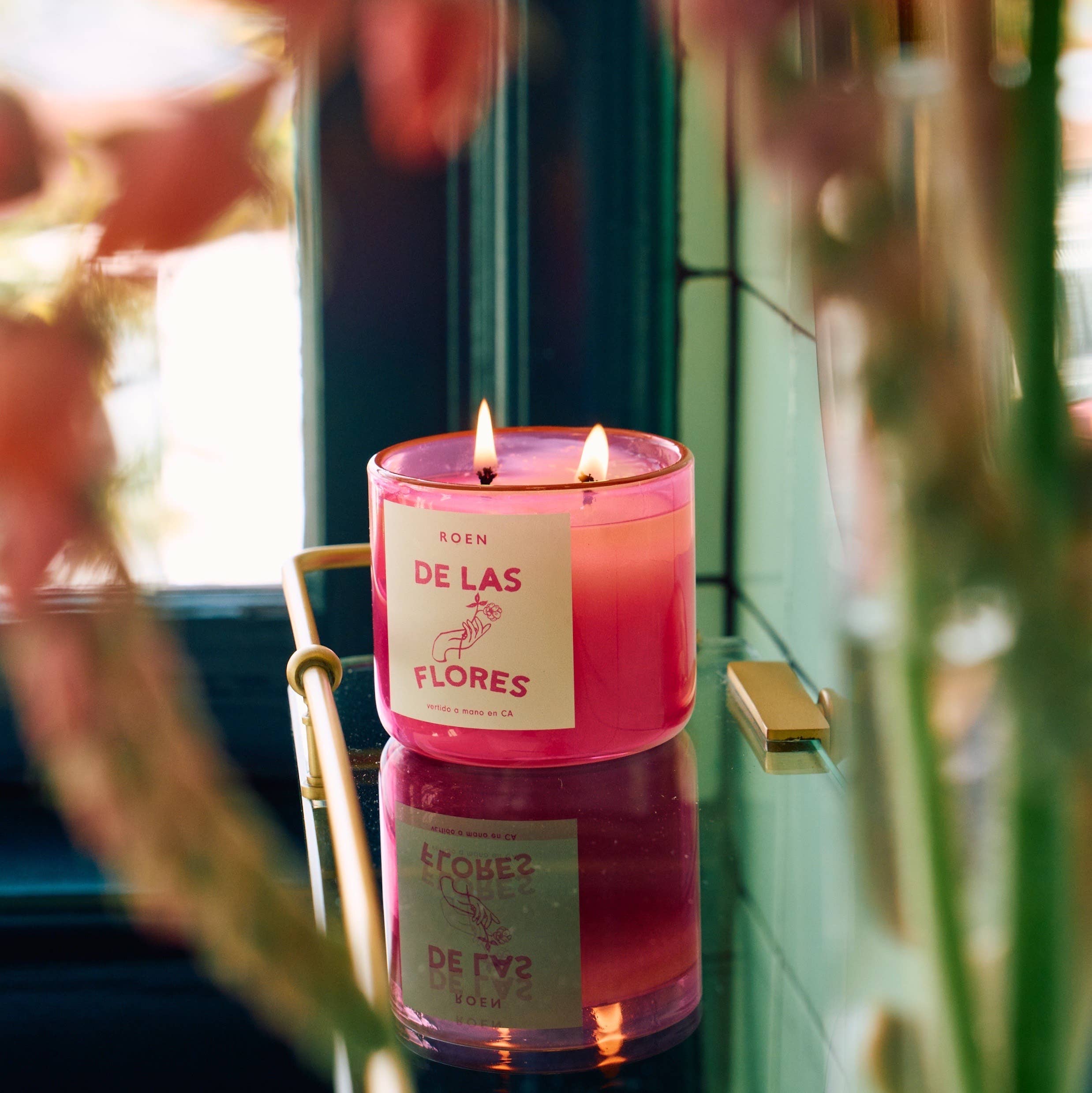 Of the Flowers scented candle in a pink glass jar with two flames