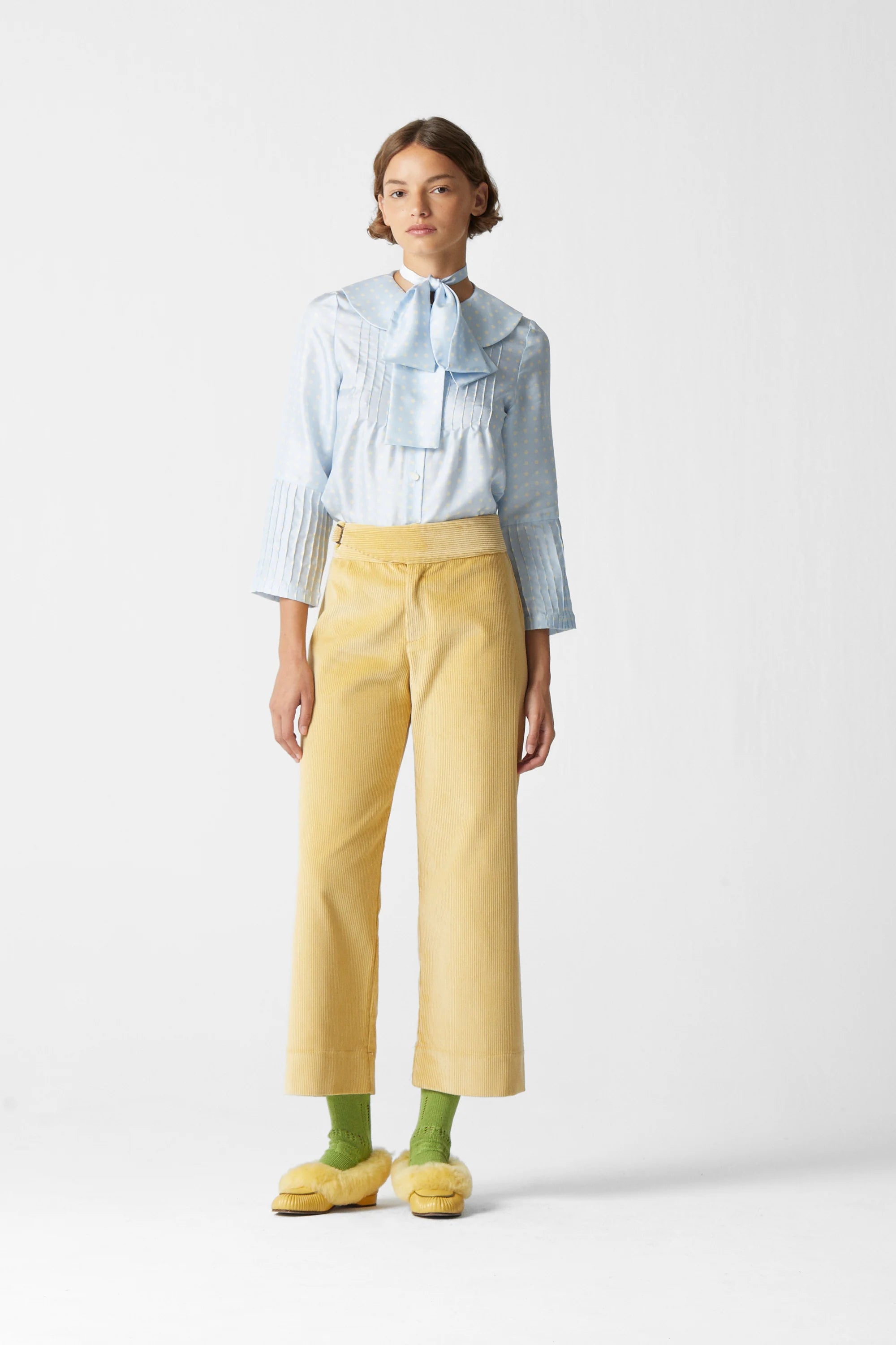 Light yellow corduroy pants on model with belt loops and straight leg