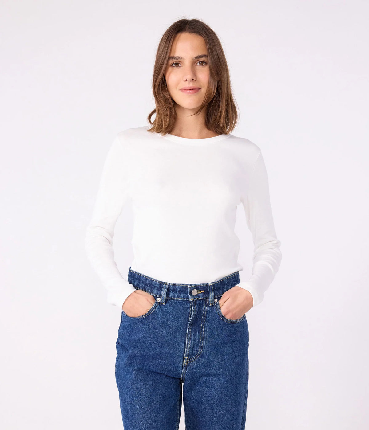 Women’s long-sleeve crew neck tee in white, worn with jeans