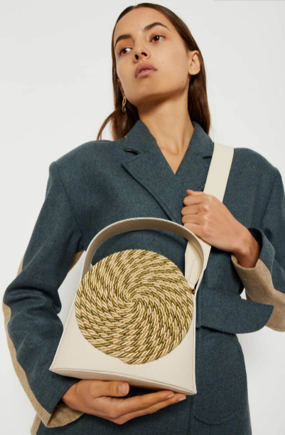 Woven multi-color mini handbag with cream handle, shown being held