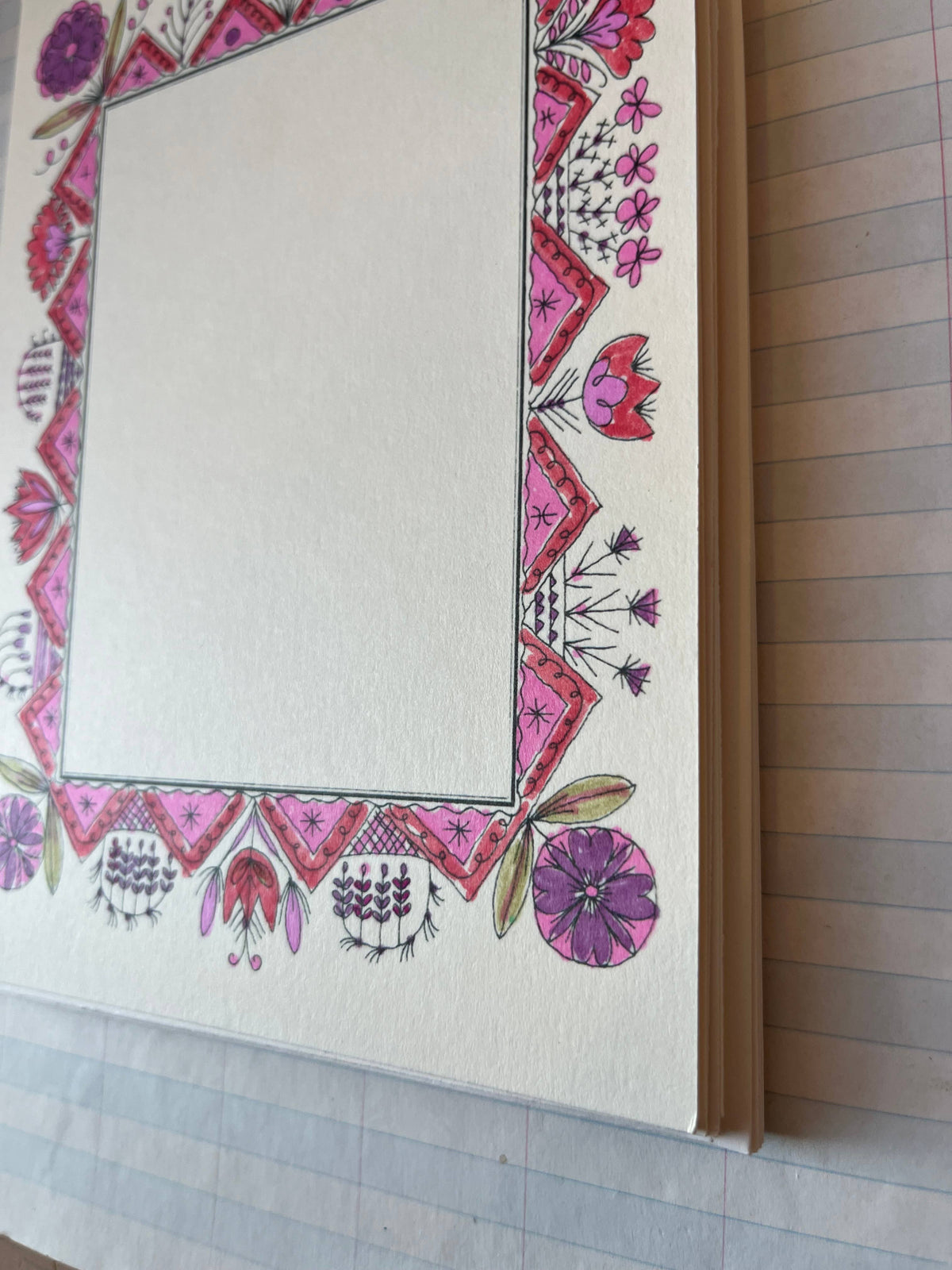 Decorative folk picture frame close-up: pink/purple floral border and diamond corners