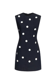 Polka dot sleeveless midi dress, black with white dots, high neckline.