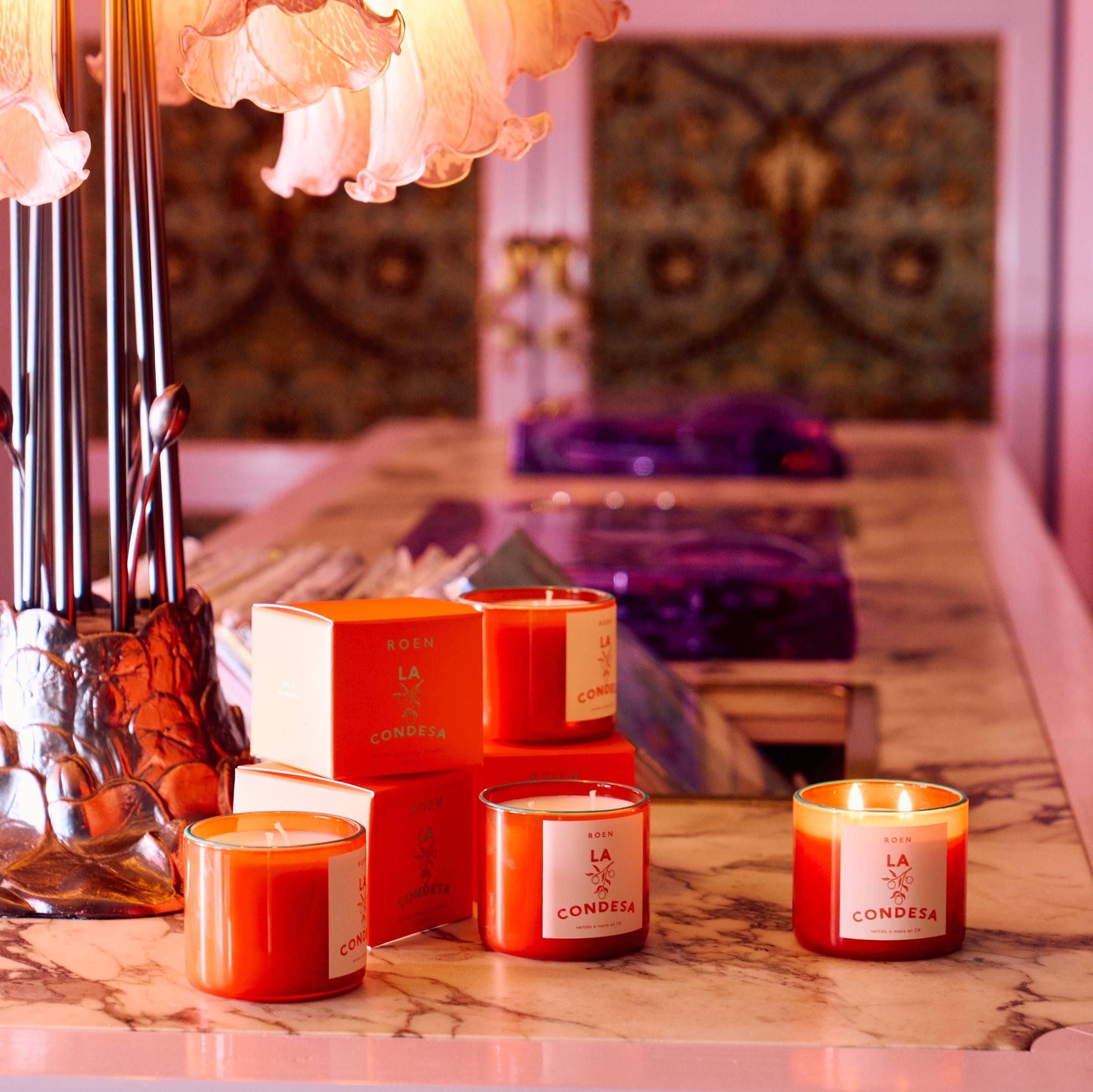 Set of scented candles in red glass with white labels and matching boxes