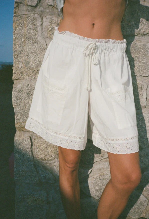 White Neria short with ruffled elastic waist, drawstring, and eyelet lace trim