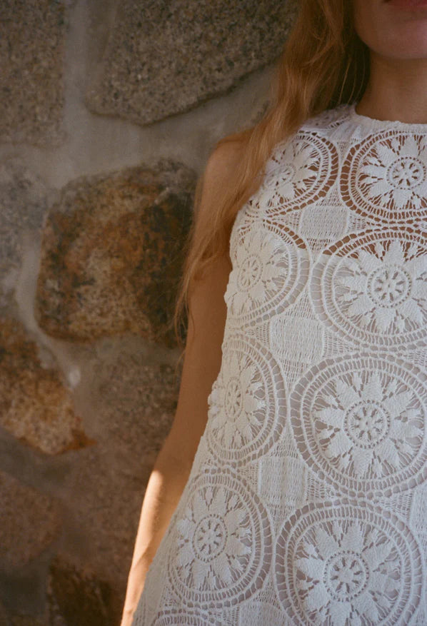 White sleeveless lace dress with detailed circular crochet motifs at bodice