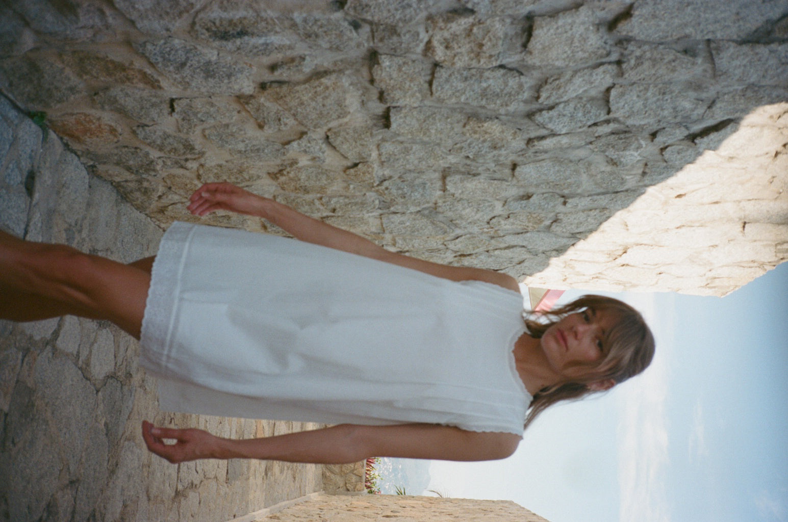 White cotton dress, sleeveless with round neck and embroidered skirt