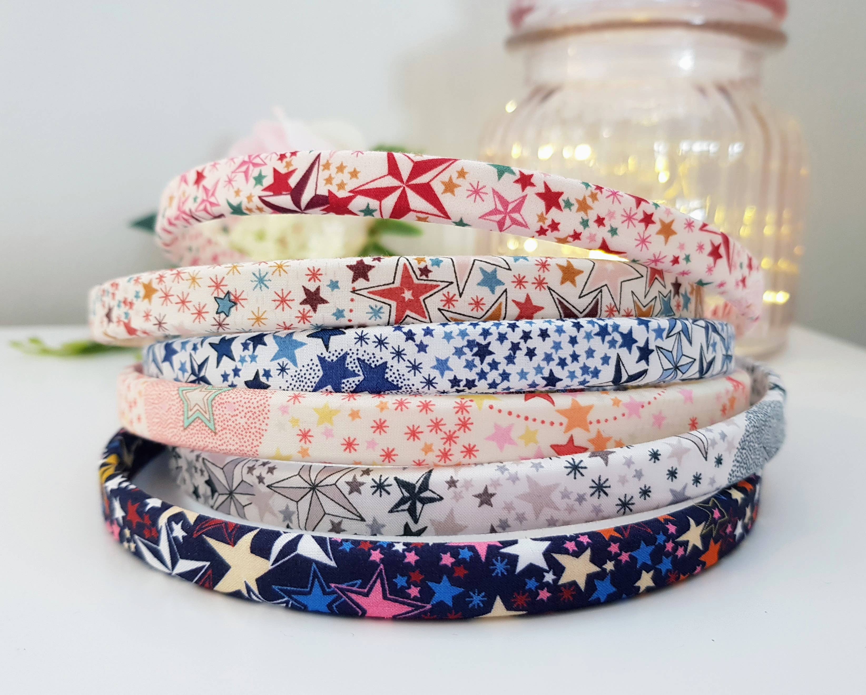 Set of patterned fabric headbands stacked, stars and snowflakes in pink and blue