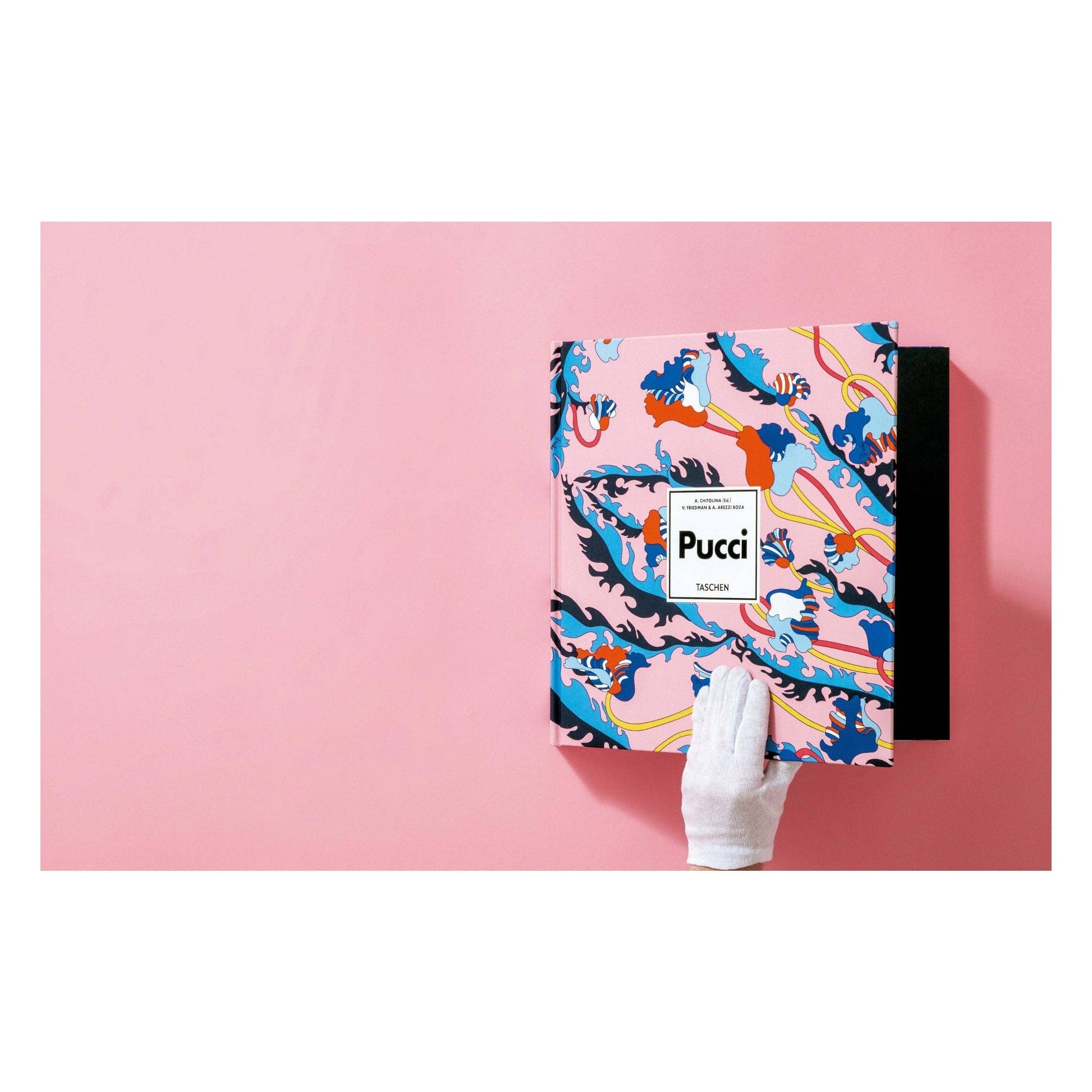 Pucci fashion book with blue and orange wave pattern cover; hand holds the book.