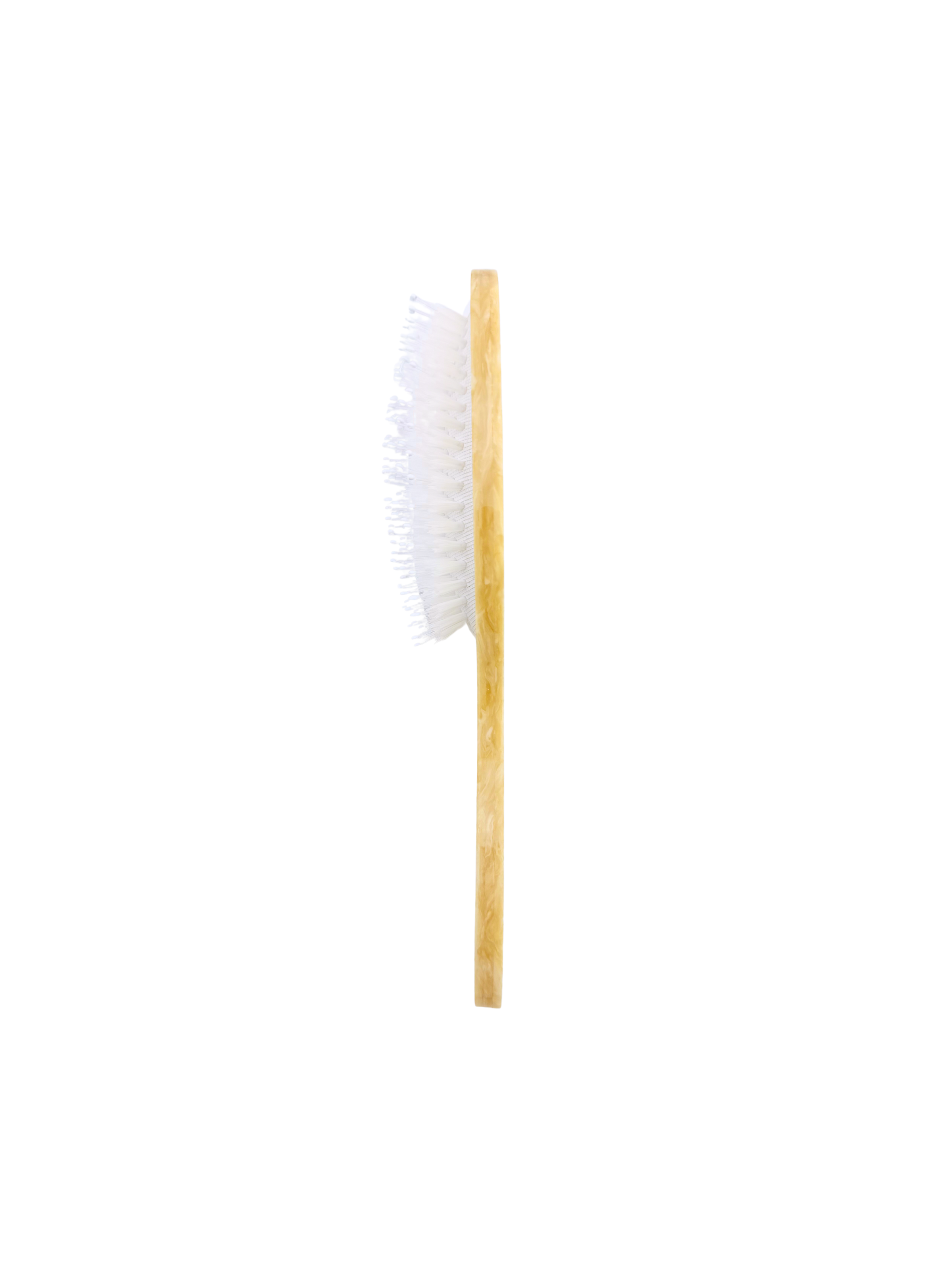 Crab hairbrush side view with white bristles on a pale wood handle