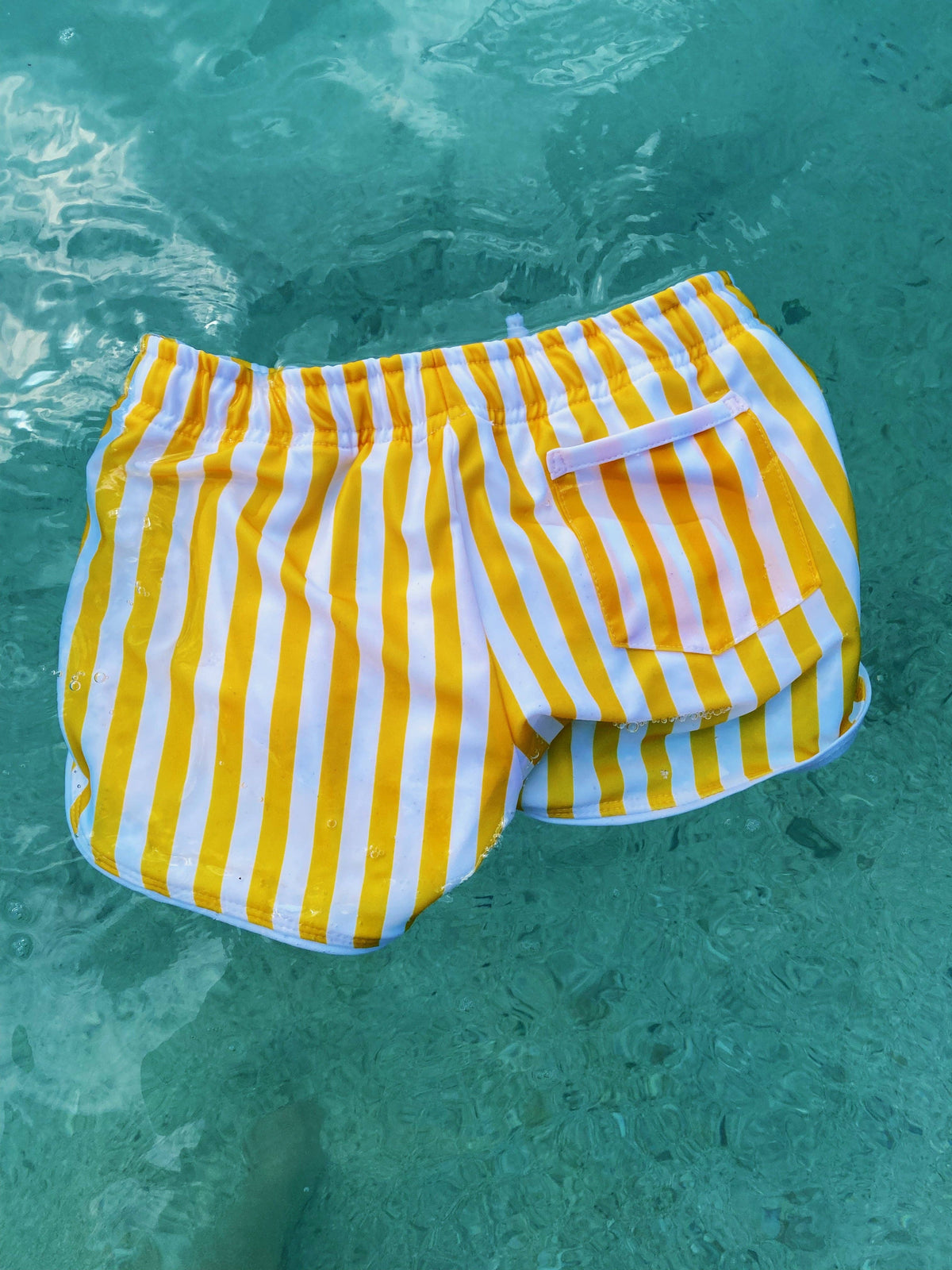 Yellow-and-white striped short shorts with elastic waist and flap side pocket