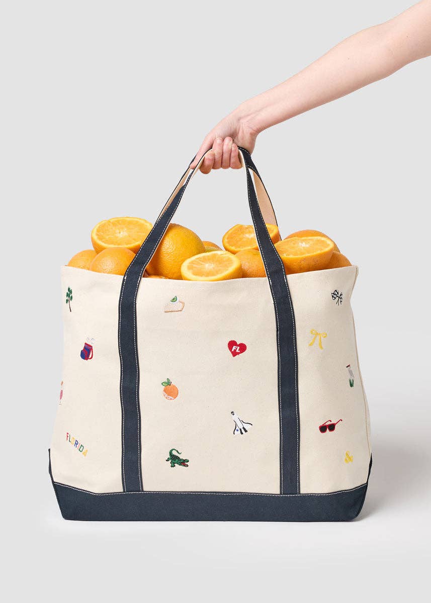 Canvas tote bag with navy trim and handles, filled with oranges, Florida icons print