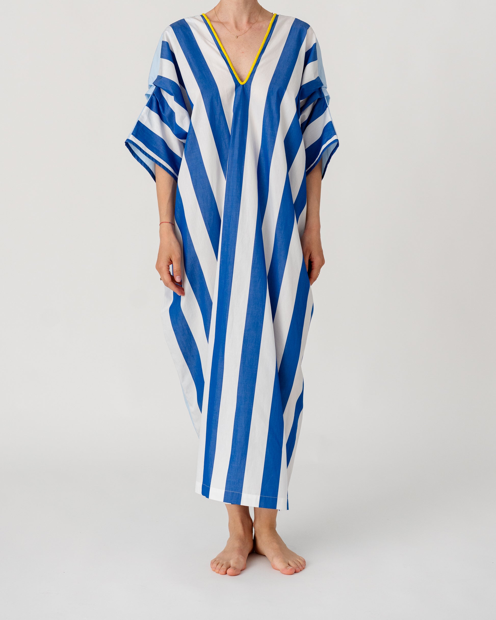Loose caftan with batwing sleeves, blue-and-white vertical stripes and yellow-trim V-neck.