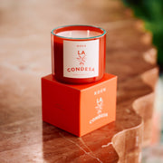 Scented candle in red glass with white label on red gift box