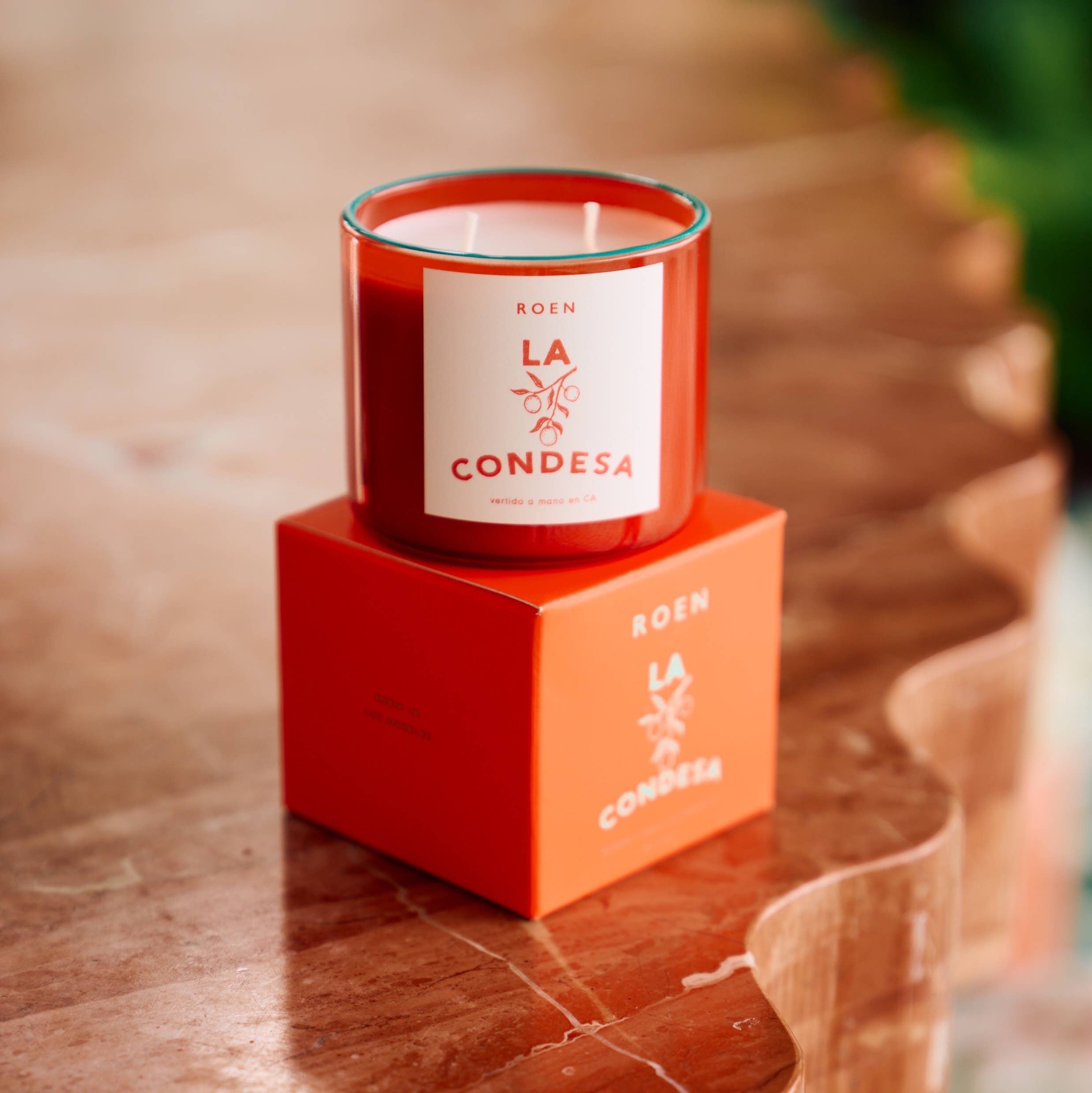 Scented candle in red glass with white label on red gift box