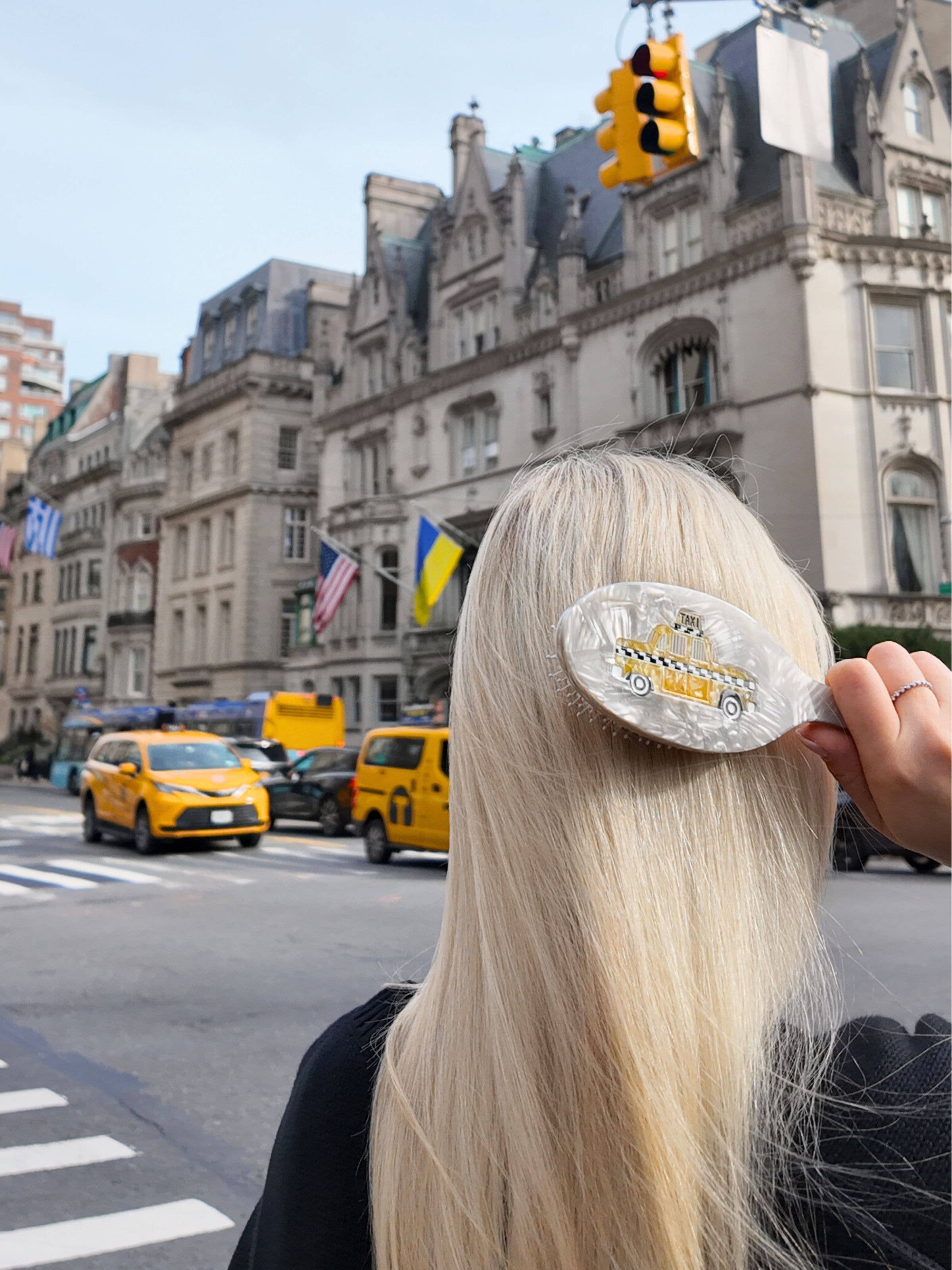 Hand-painted taxi hair brush resting on blonde hair, rounded bristle pad