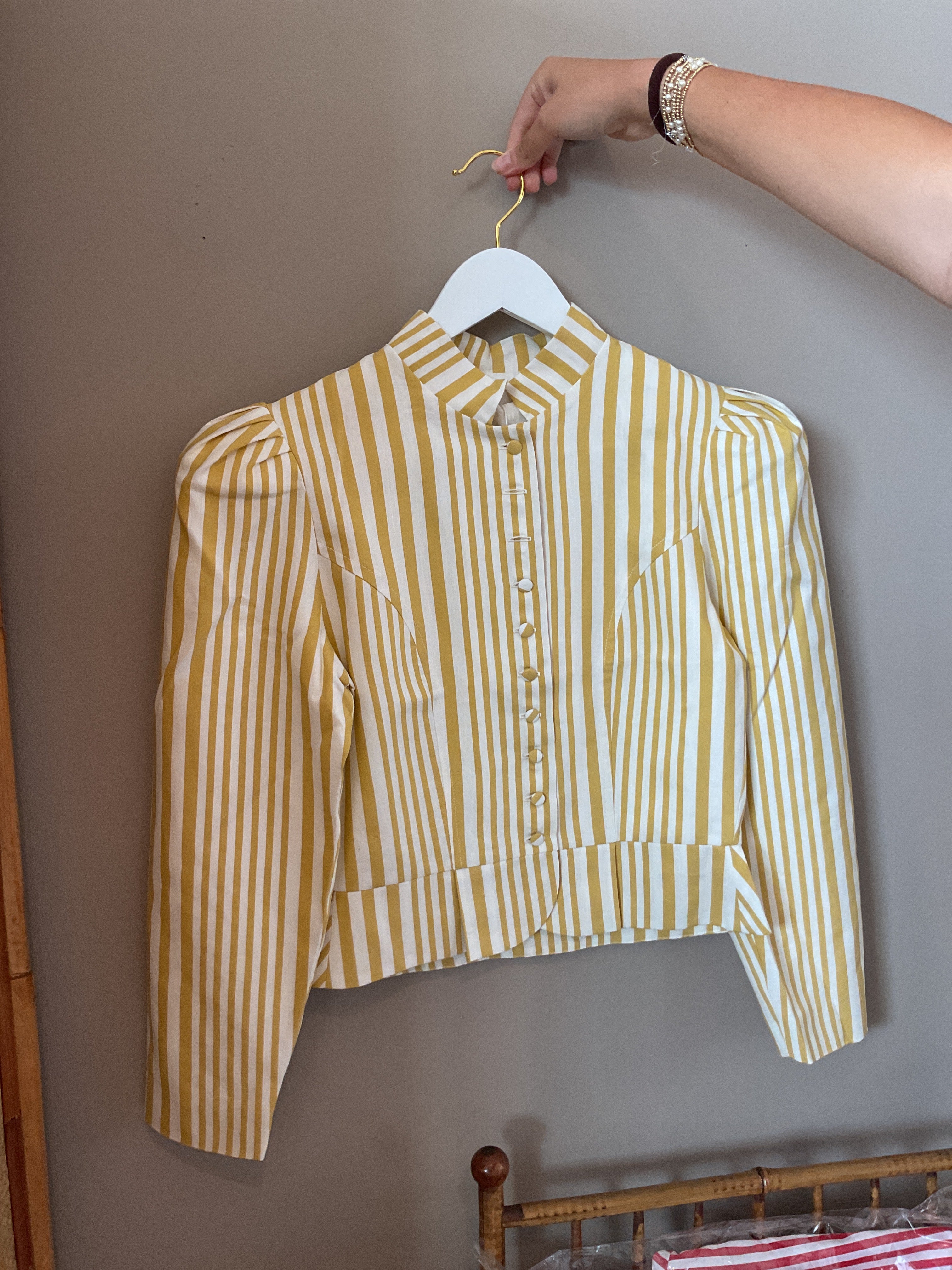 Striped button-front jacket on hanger, long sleeves with puffed shoulders