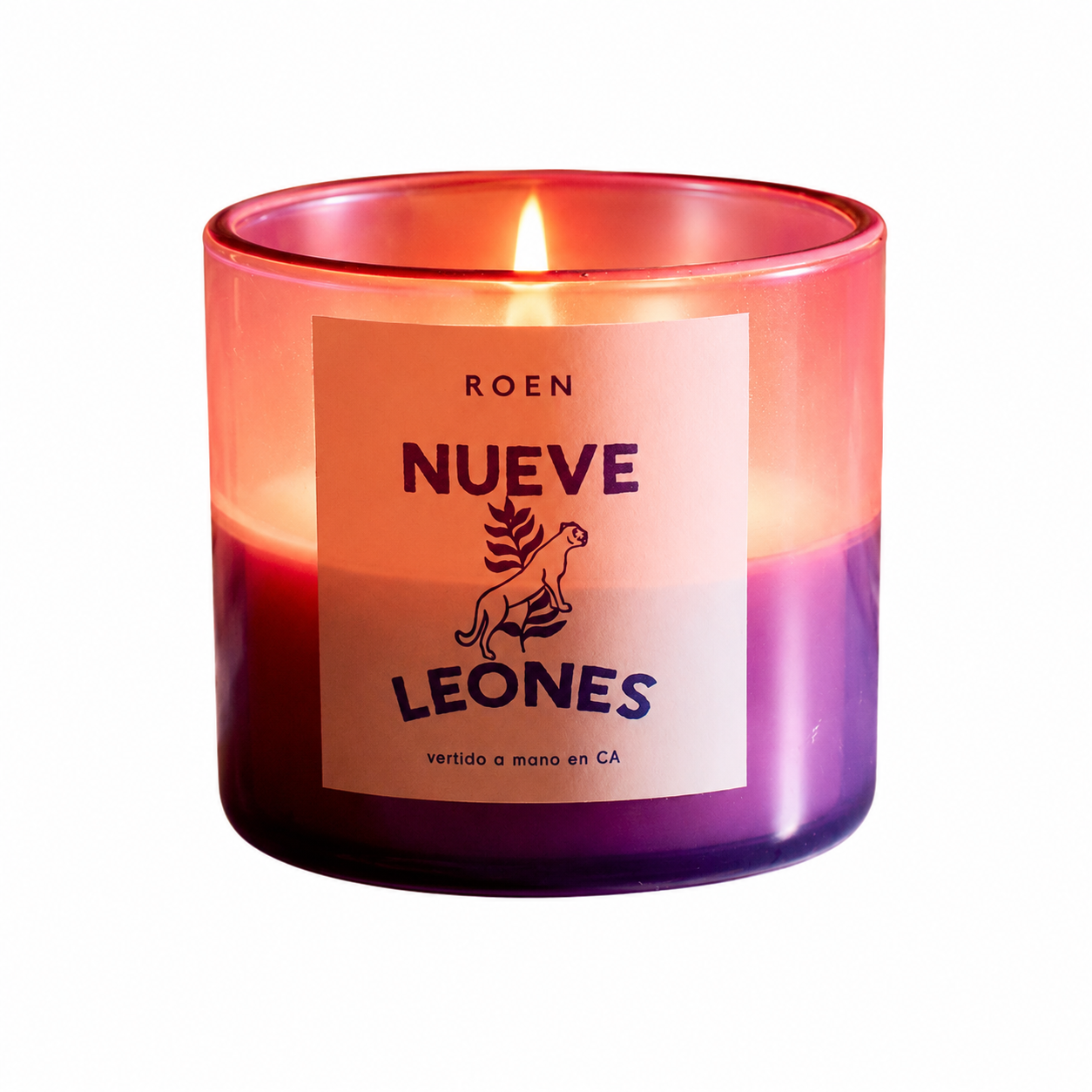 Scented candle in a glass jar, red to purple wax layers, lit flame