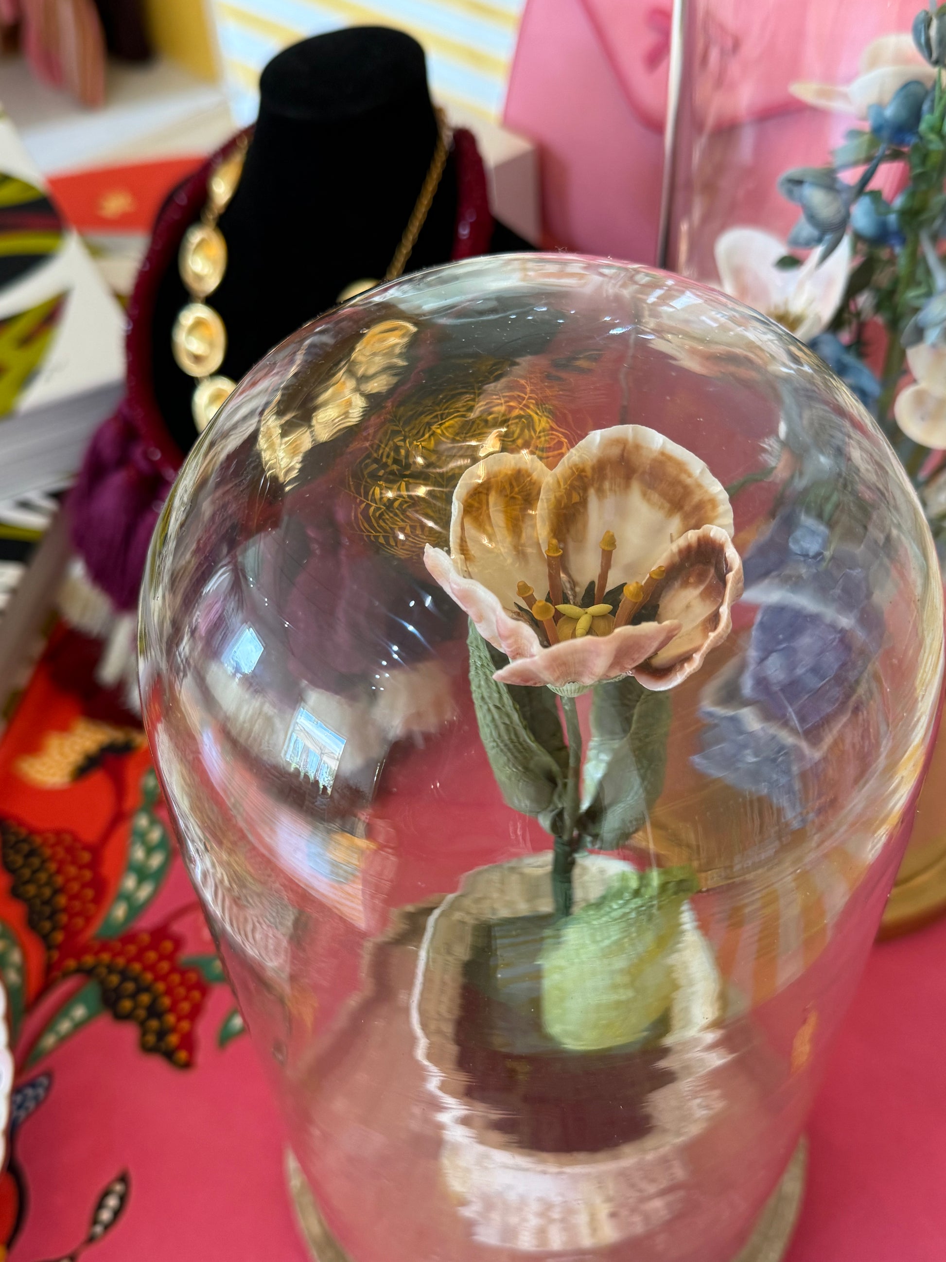 Glass dome tulip centerpiece with detailed pink petals on green stem