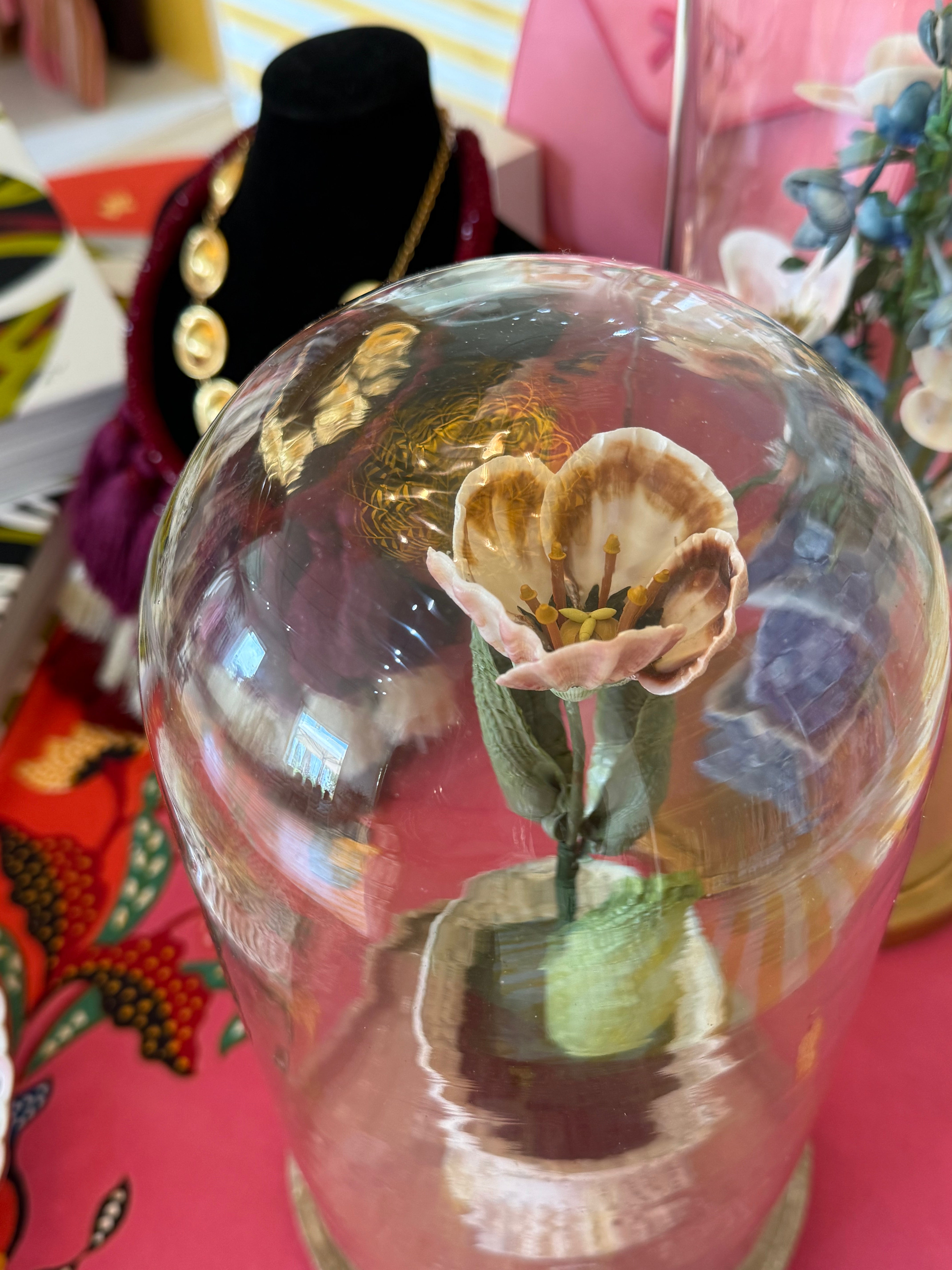 Glass dome tulip centerpiece with detailed pink petals on green stem