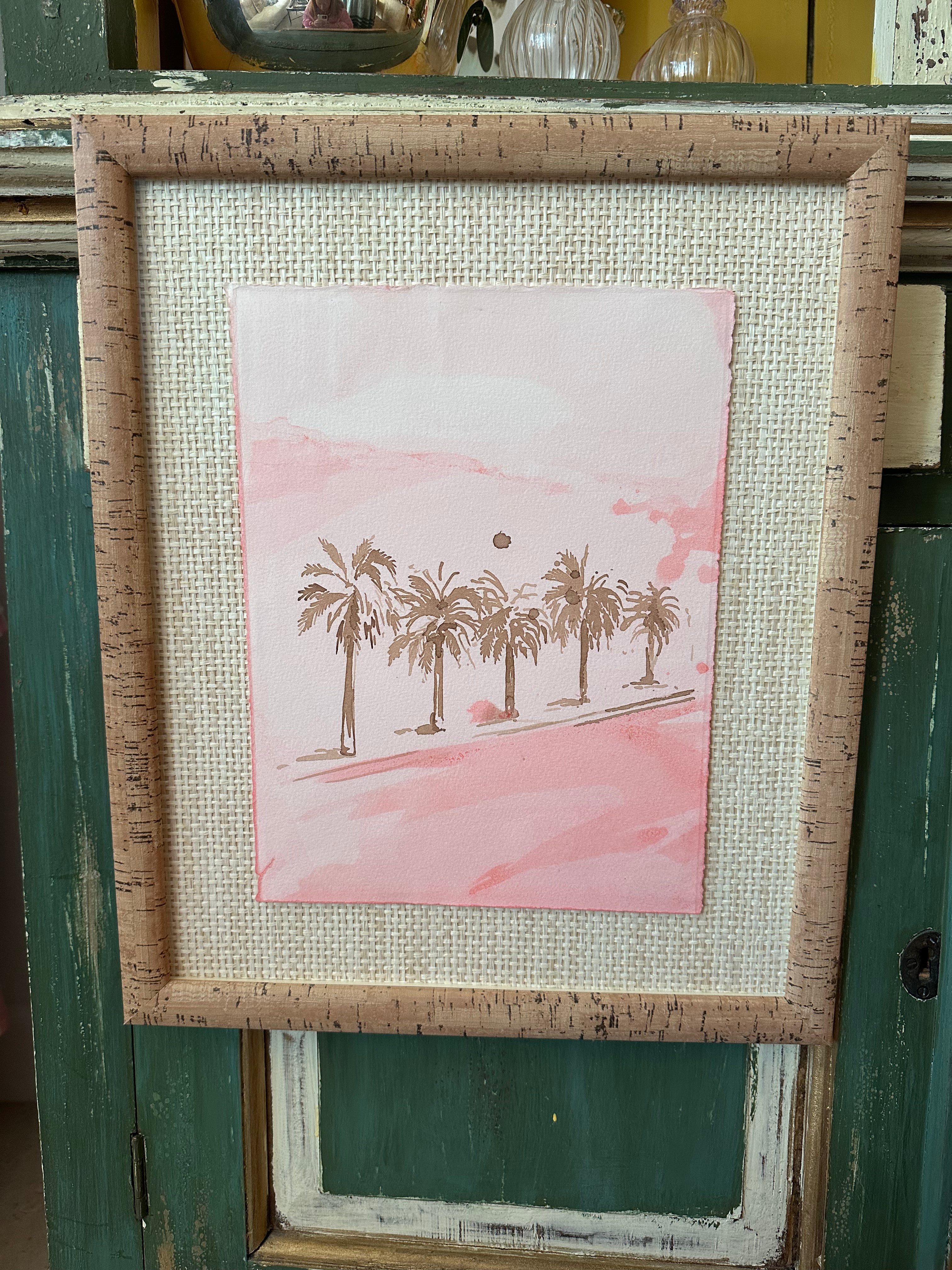 Framed pink palm watercolor print with palm trees on textured cork frame