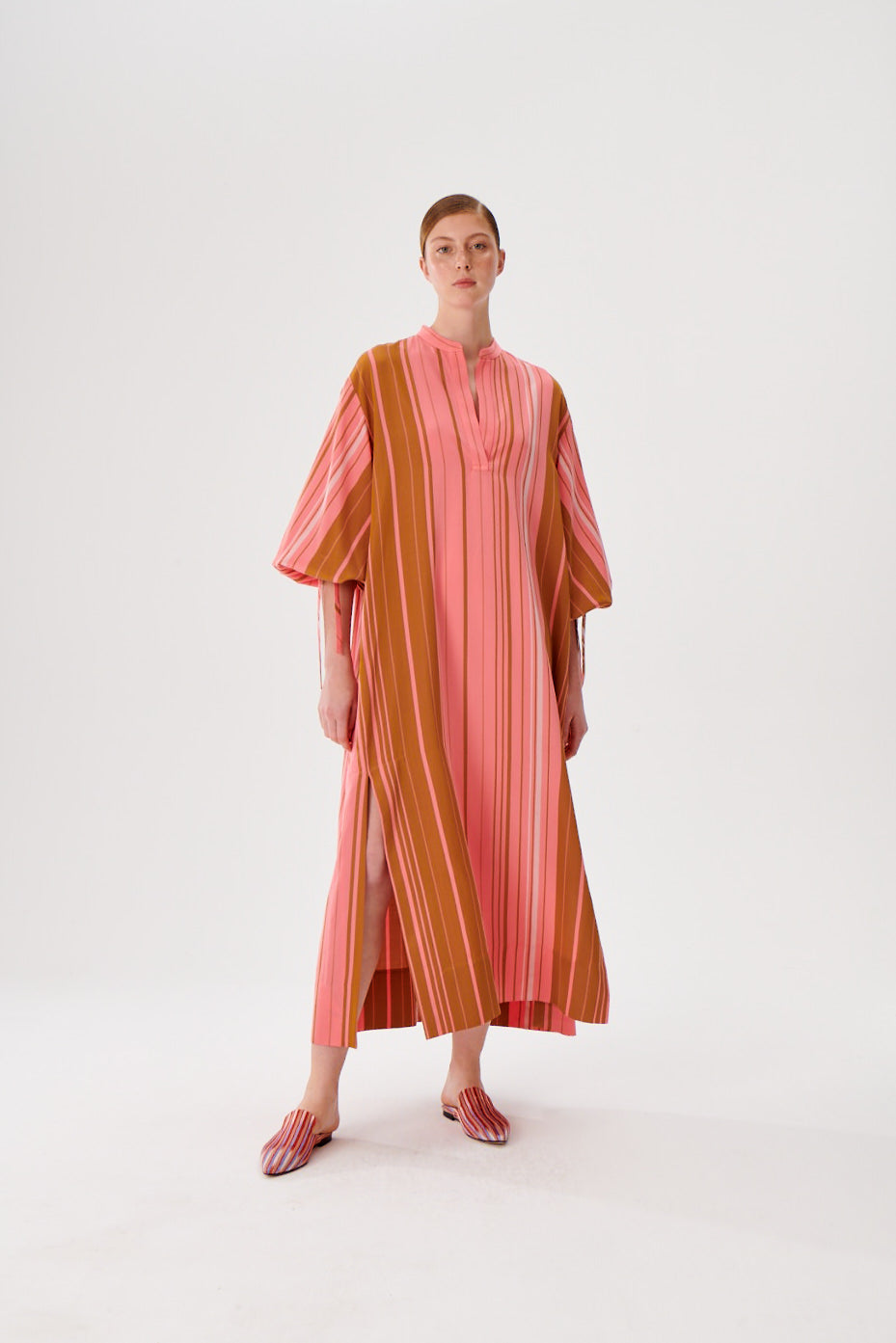 Maxi caftan dress front view, pink and rust vertical stripes, split neckline, flowy maxi length.