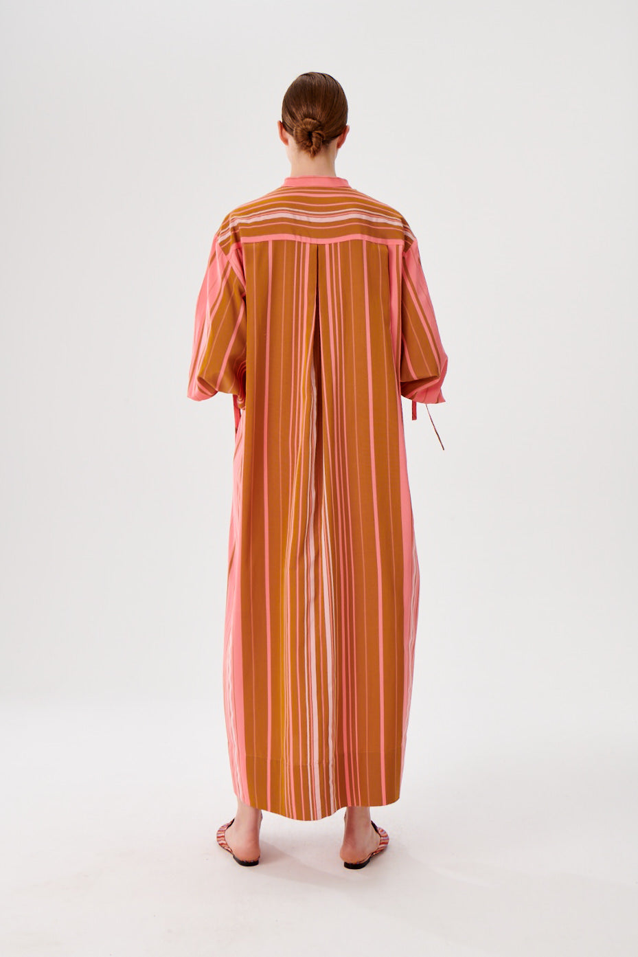 Maxi caftan dress back view, pink and rust vertical stripes, relaxed maxi length, wide sleeves.