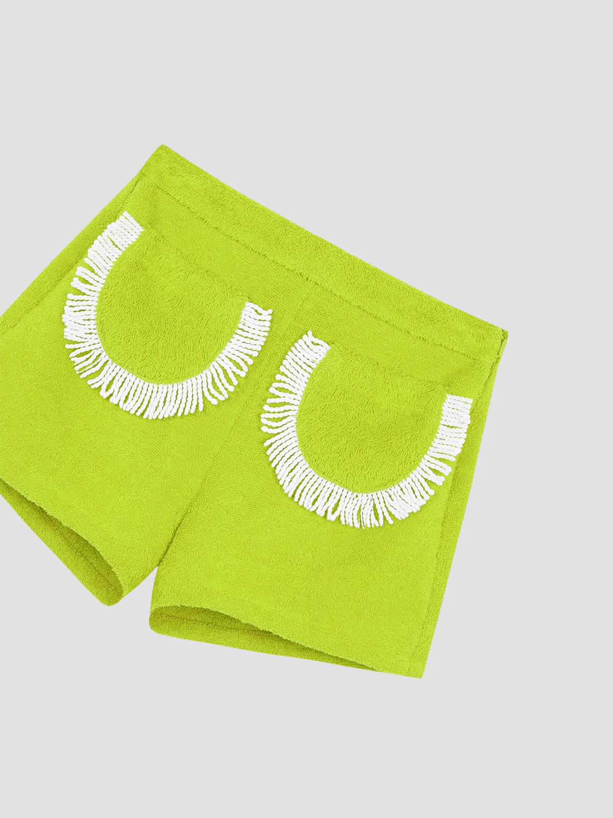 Lime green fringed shorts, angled view, with white crescent embroidery
