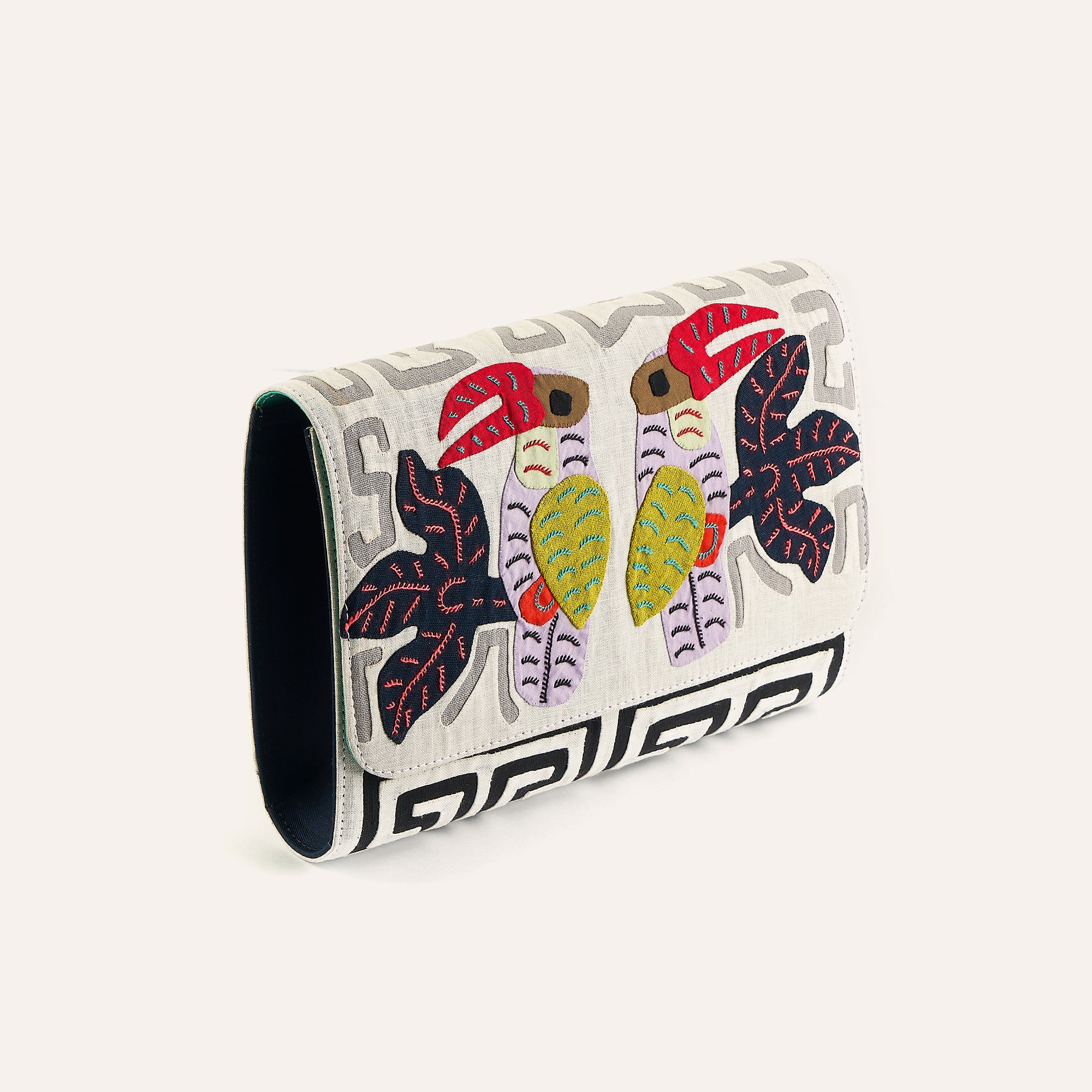 Cream clutch with multicolor elephant applique and bold Greek key trim on flap