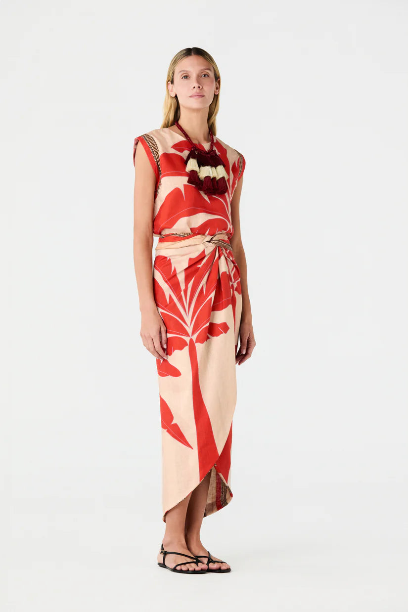 Sleeveless linen top on model, red and cream palm print with asymmetrical drape hem