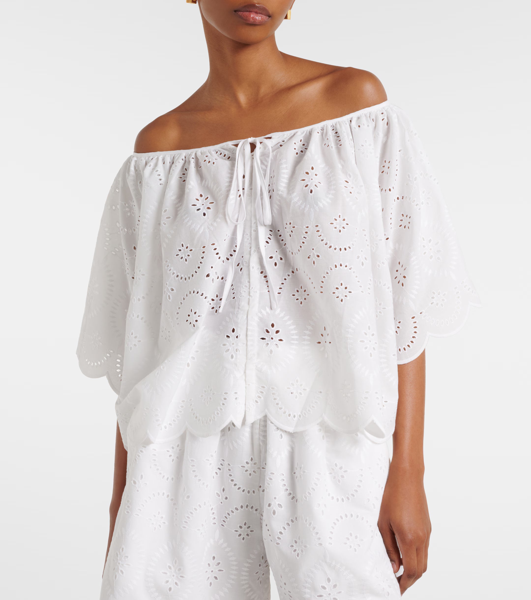 White off-shoulder eyelet top with drawstring neck tie and loose fit sleeves