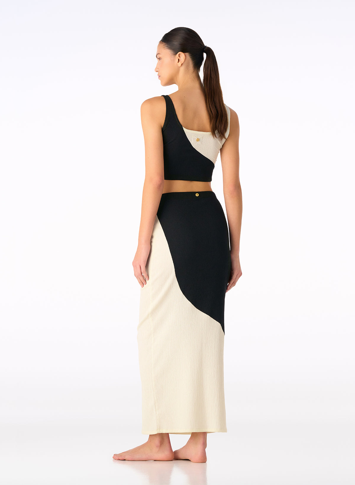 Onyx and ivory color-block knit set with sleeveless crop top and high-waist skirt, side