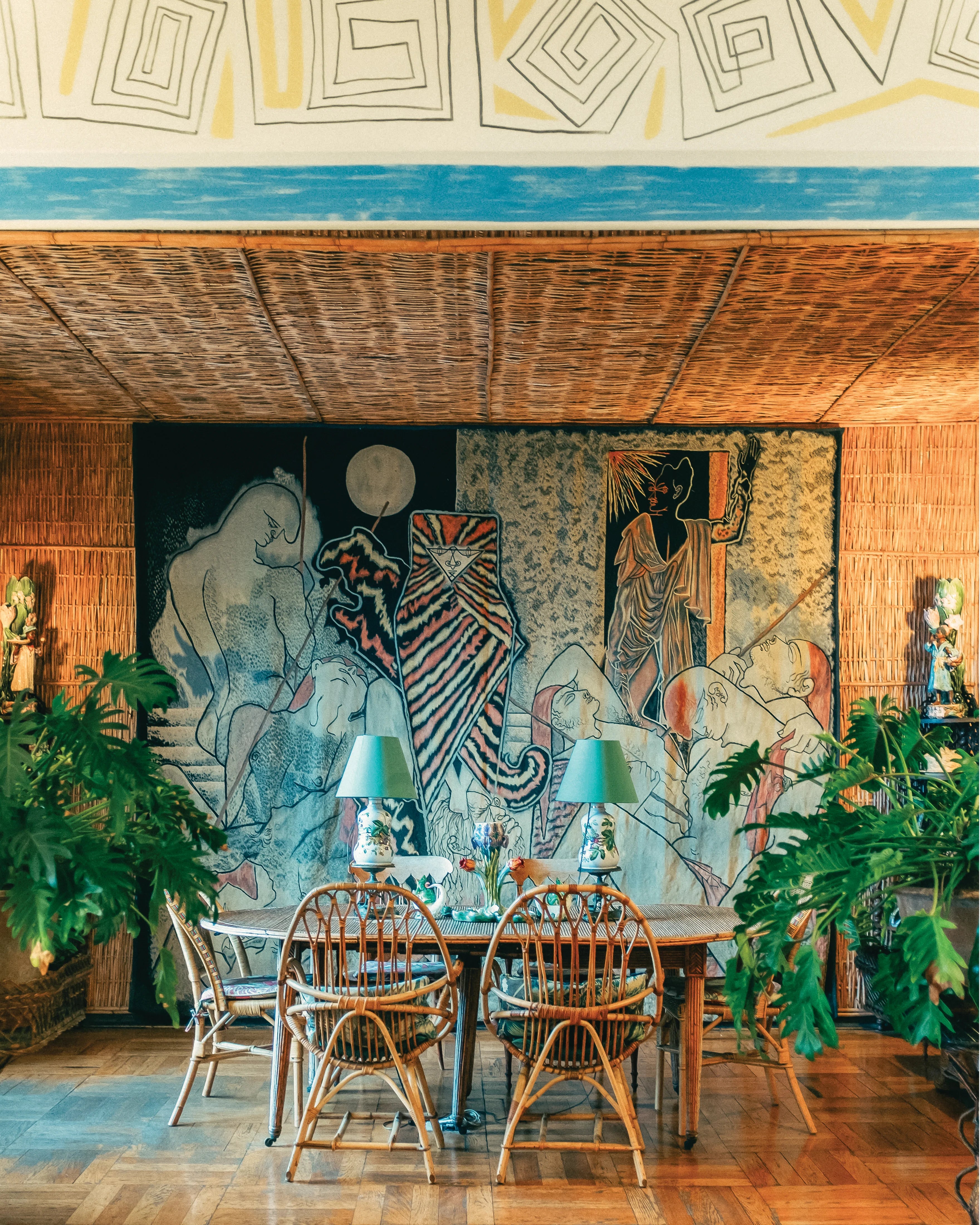 Rattan book page showing rattan dining set with chairs before a mural wall