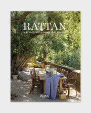 Rattan book cover with outdoor dining table and rattan chairs beneath a tree