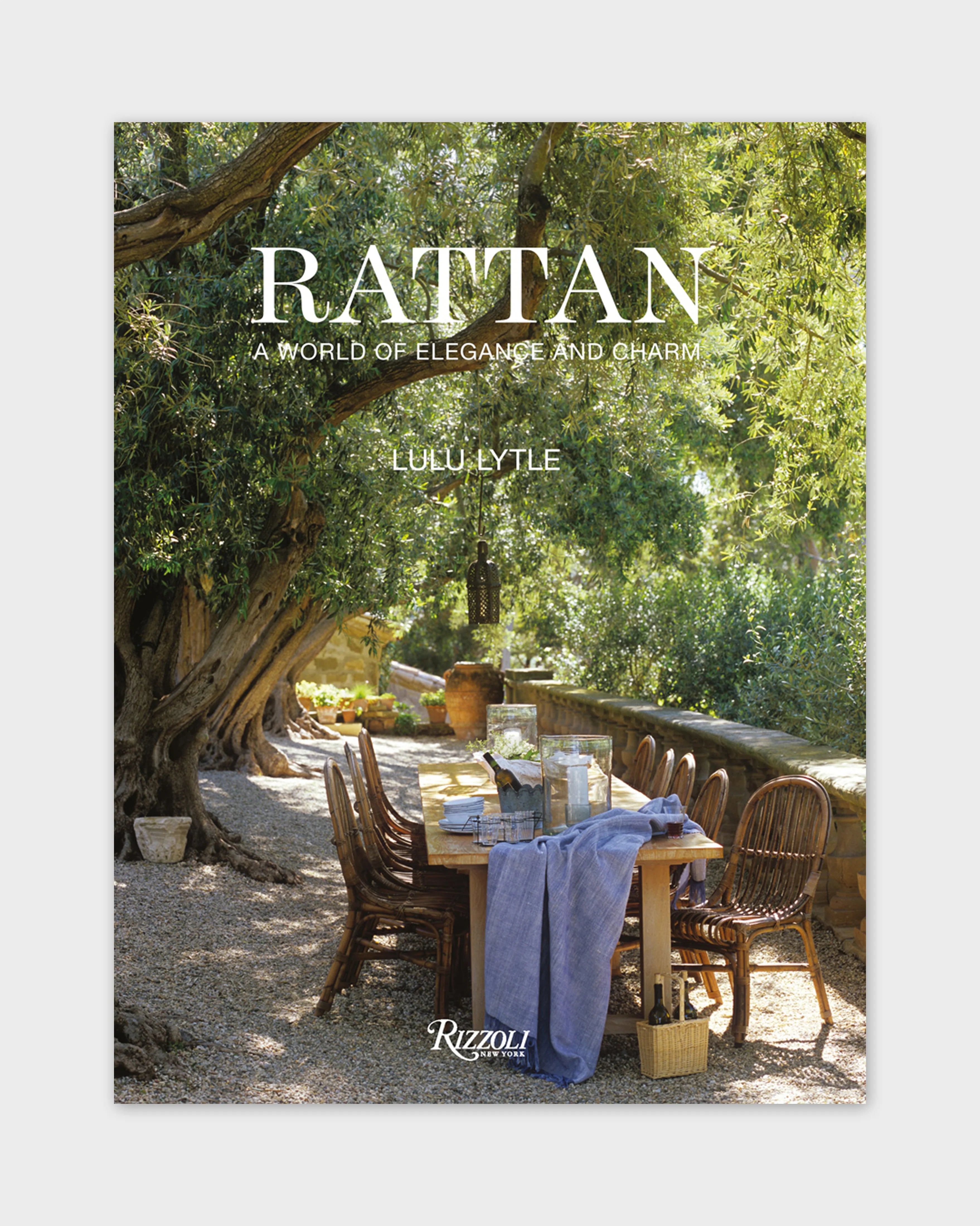 Rattan book cover with outdoor dining table and rattan chairs beneath a tree