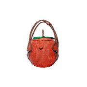 Peach woven handbag with brown leather handles, orange body, green top flap