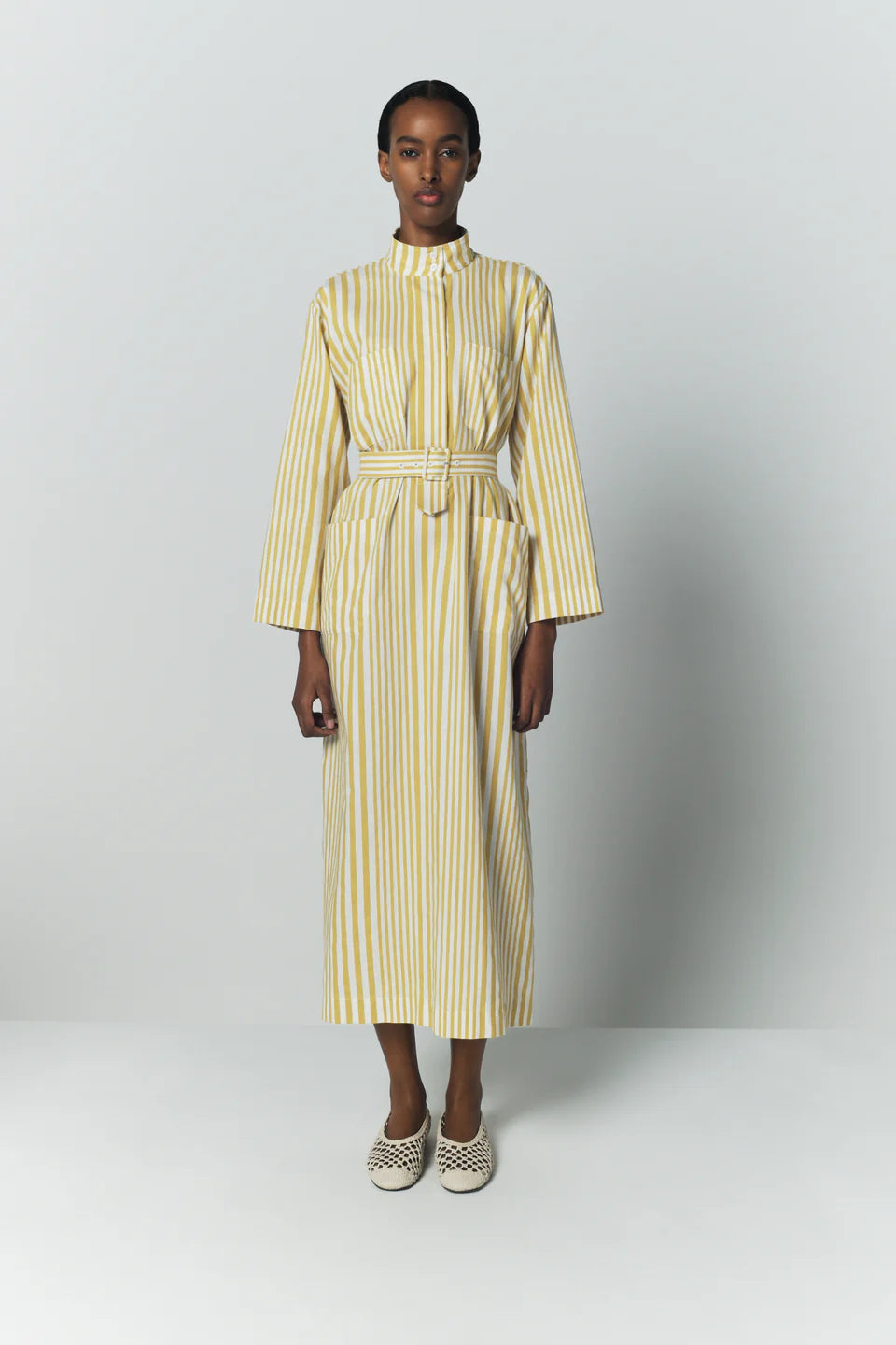 Striped belted dress with long sleeves, stand collar, midi length, and yellow-and-white stripes