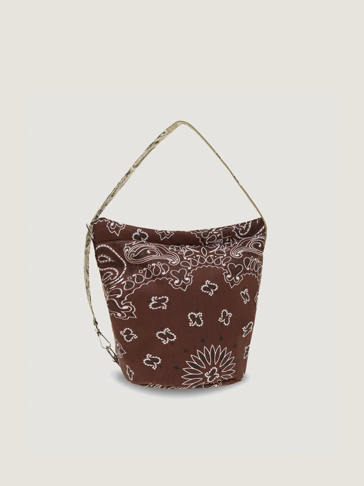 Brown bucket bag with beige paisley-print shoulder strap and white bandana pattern