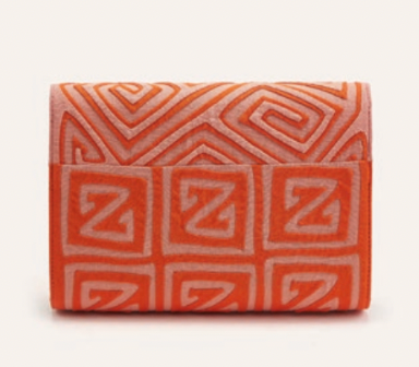 Guacamaya clutch with orange geometric icons on back, folded flap detail