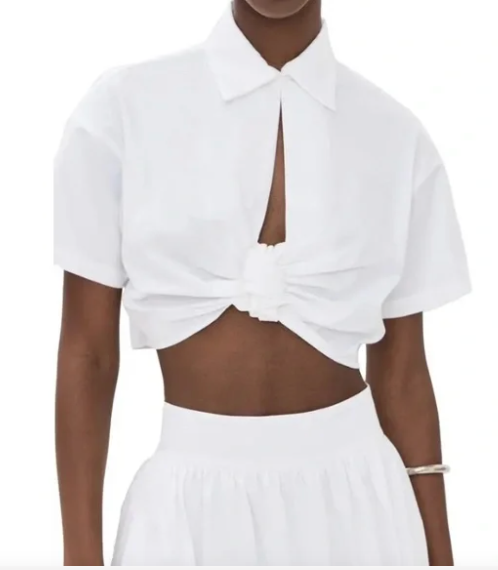 White blouse with pointed collar, keyhole slit front, and knotted waist detail