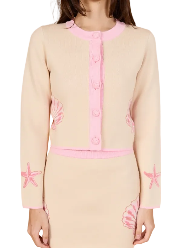 Beige cardigan with pink button placket and shell graphics on sleeves, crew neckline