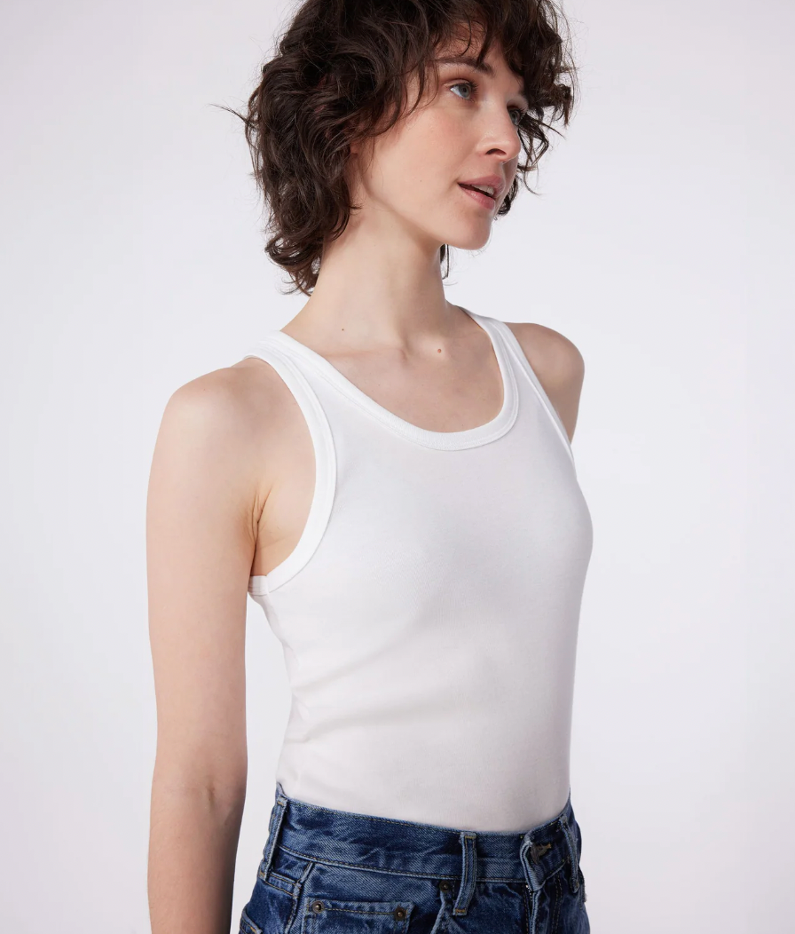 White tank top worn by model with scoop neck and wide straps