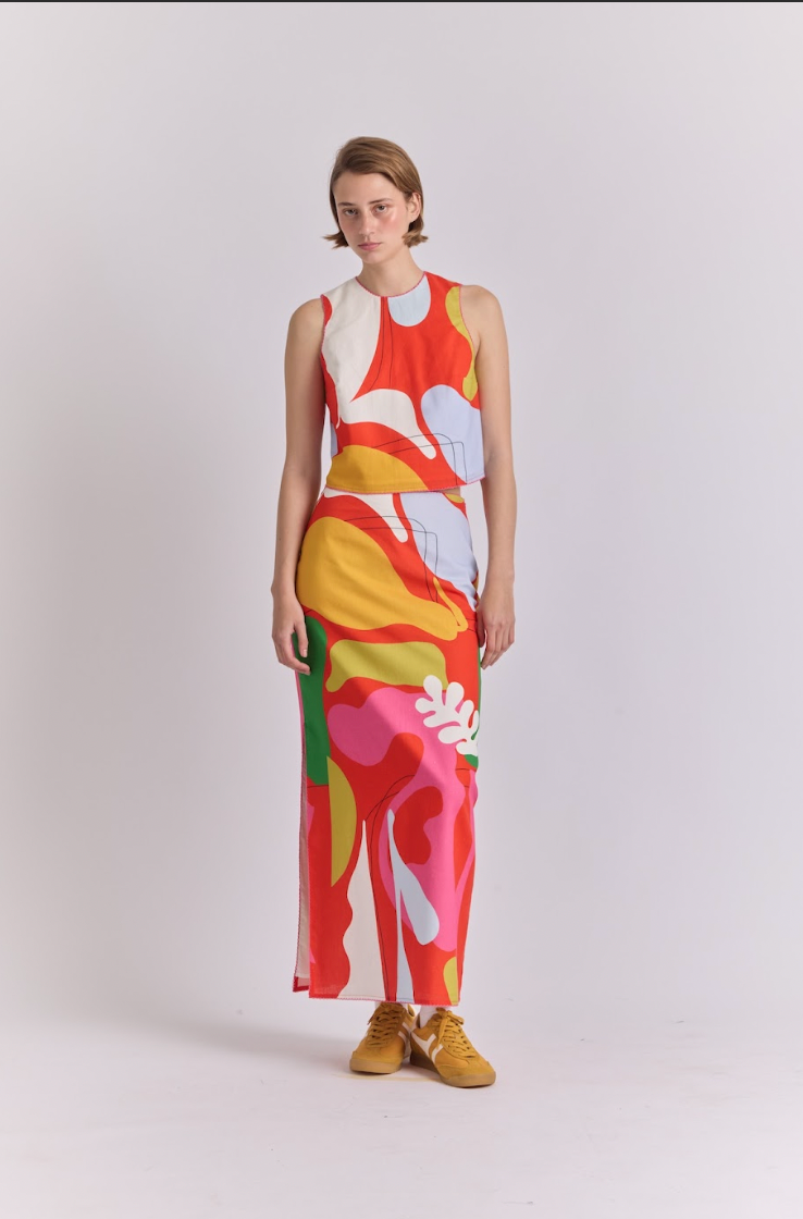 Polen skirt worn front, straight midi with colorful abstract print in red, pink, and yellow
