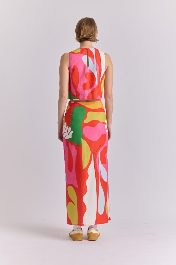 Polen skirt worn back, straight midi with large abstract hand motif in red and pink